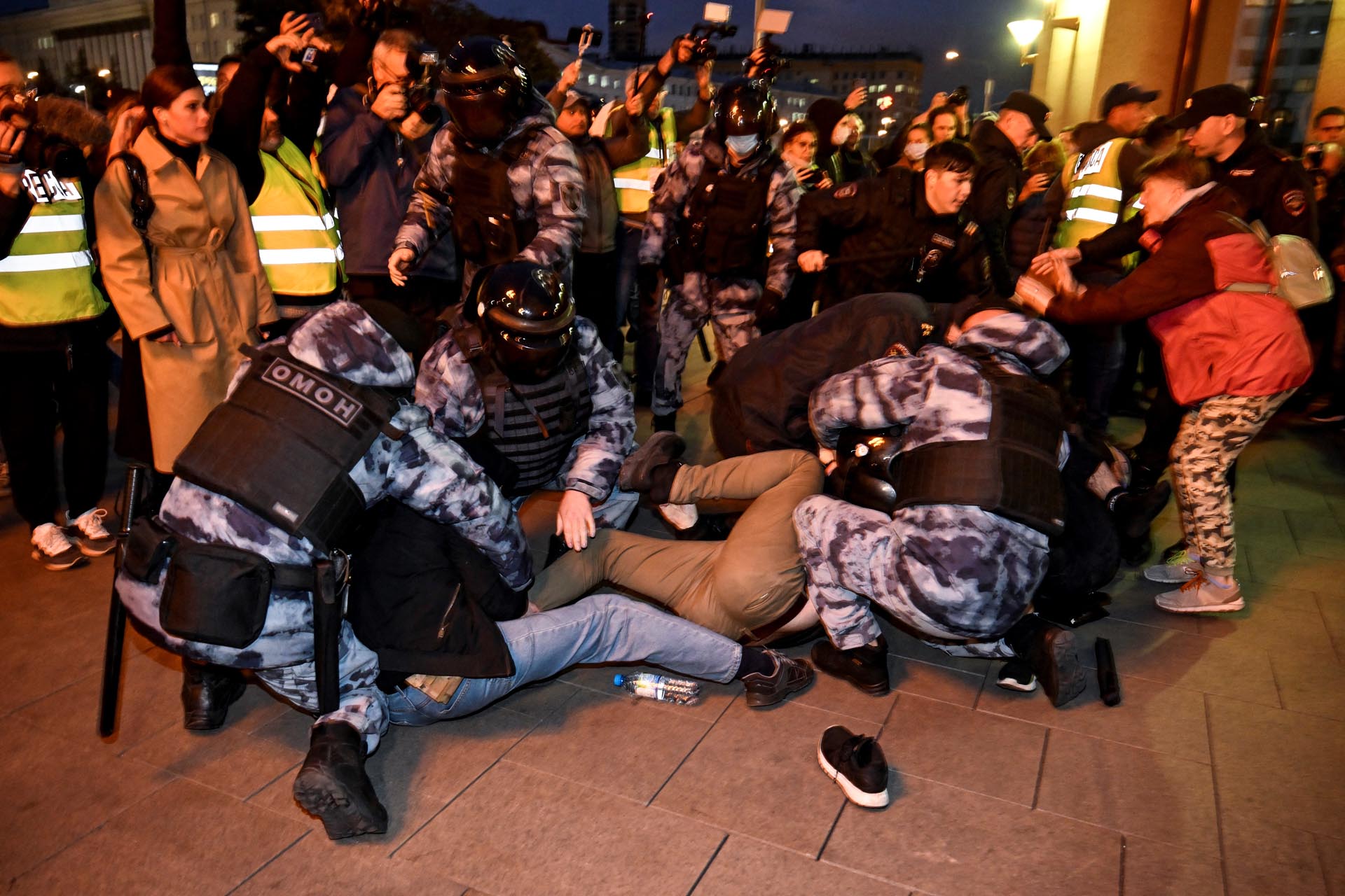 A group tries to resist after being thrown to the ground by officers (Photo by Alexander NEMENOV / AFP)