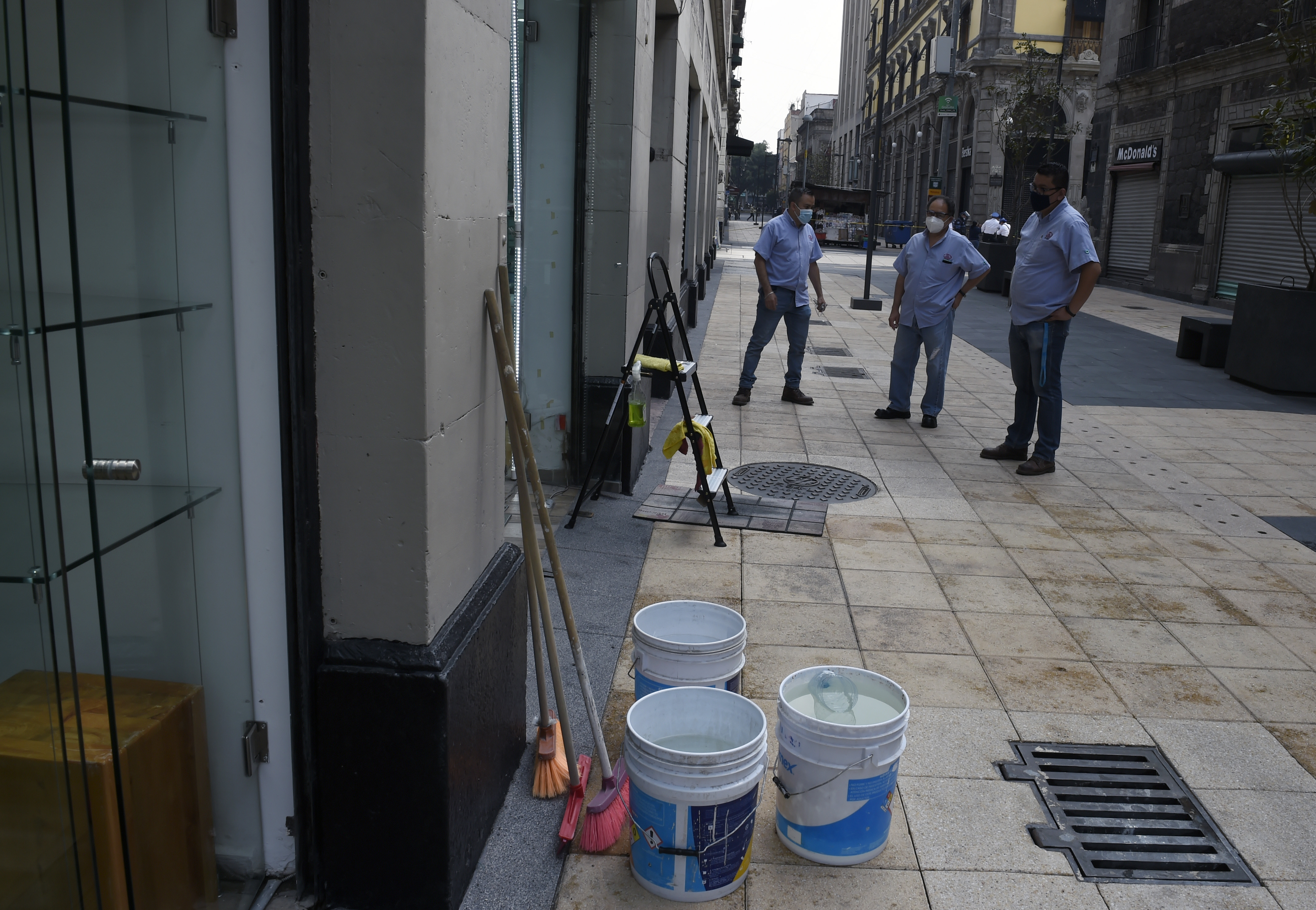 Los empleados limpian la óptica antes de volver a abrir en la Ciudad de México el 29 de junio de 2020 durante la pandemia COVID-19. (Foto: ALFREDO ESTRELLA / AFP)