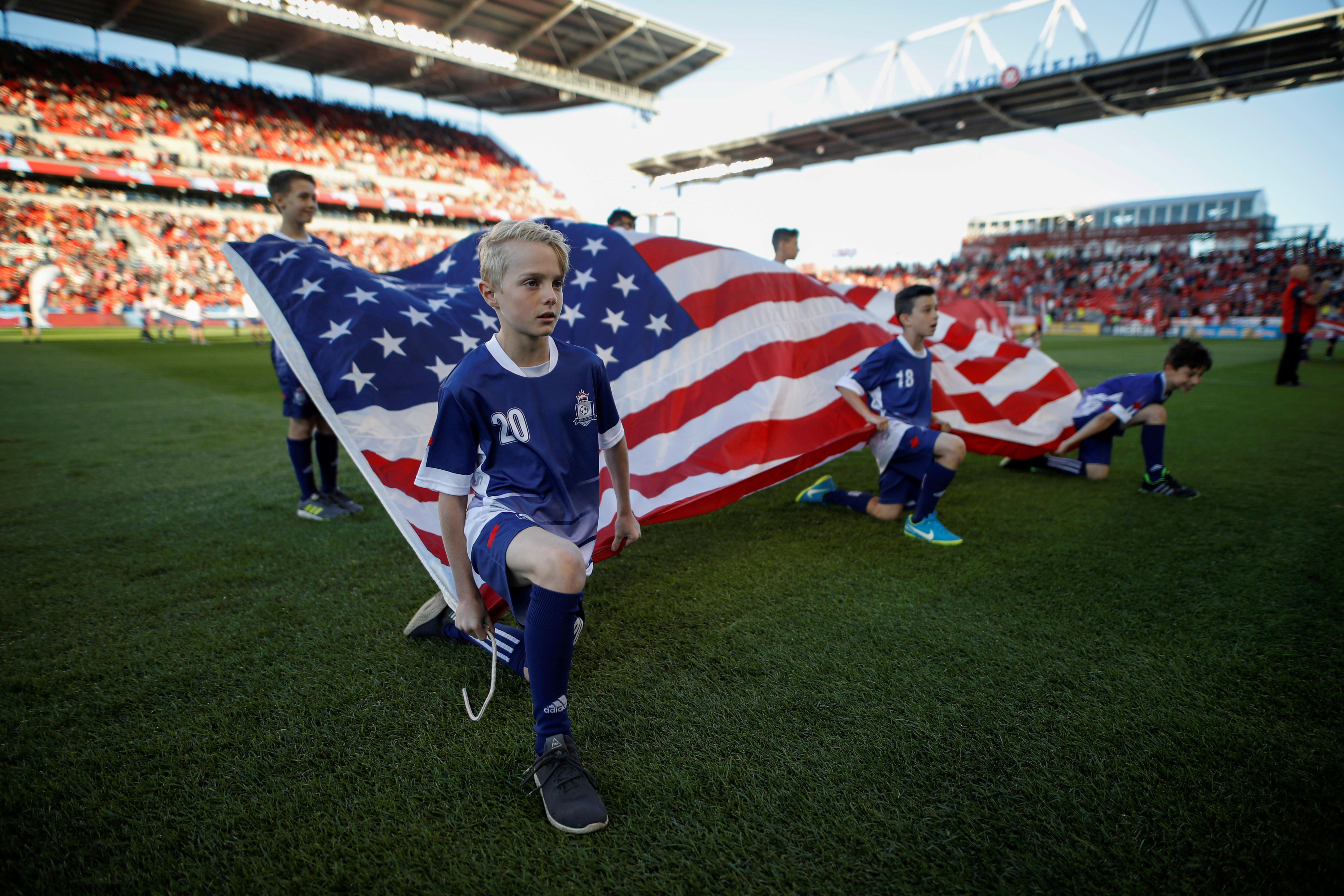FILE PHOTO: Kids hold an American flag during the national anthems before Toronto FC play D.C. United in their MLS soccer match, at BMO Field, a venue for the 2026 FIFA World Cup, in Toronto, Ontario, Canada, June 13, 2018.    REUTERS/Mark Blinch/File Photo