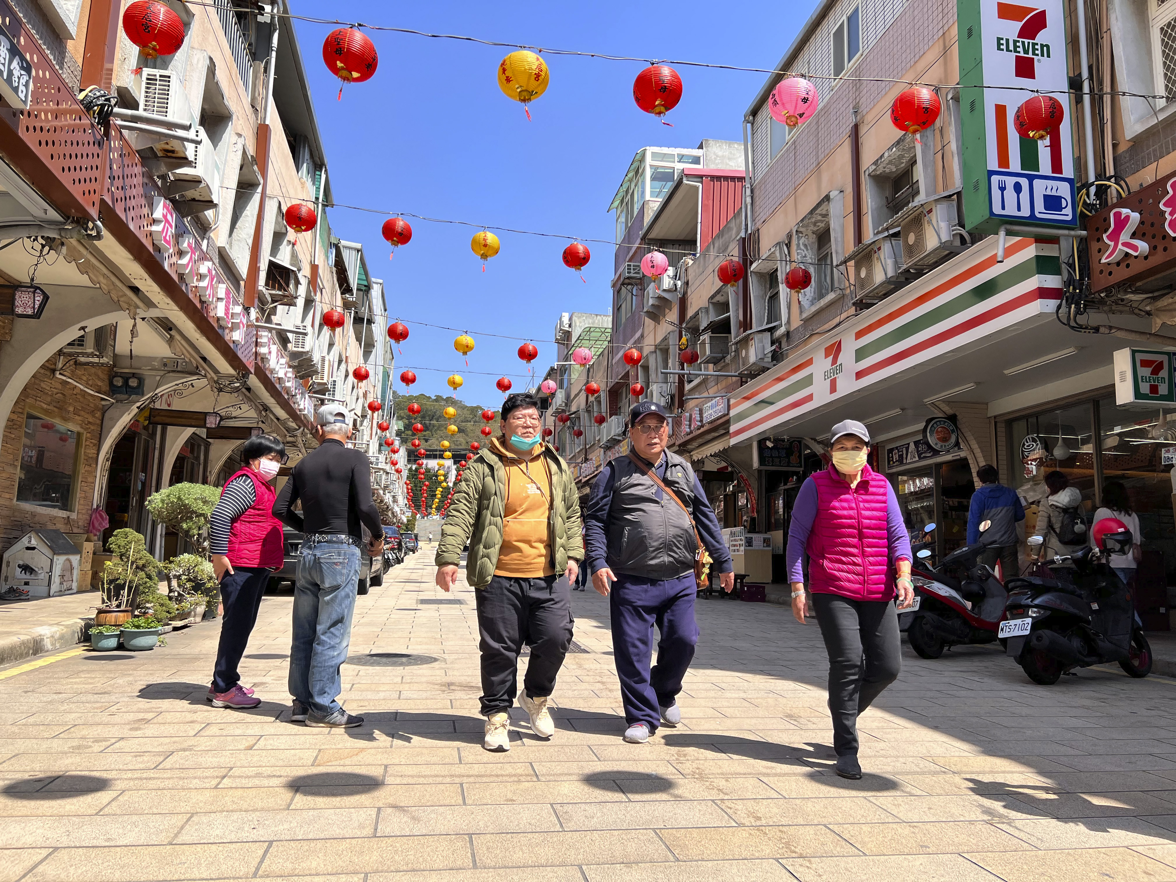 Los turistas fueron vistos caminando por la calle en el distrito comercial de Nangan. (AP/Johnson Lai)