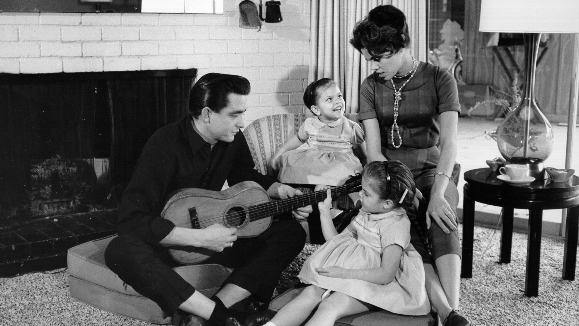 El cantante y compositor de música country Johnny Cash con una guitarra mientras su primera esposa, Vivian Liberto, y sus hijas, Rosanne y Kathy comparten un momento distendido, en 1957.
(Photo by Michael Ochs Archives/Getty Images)
