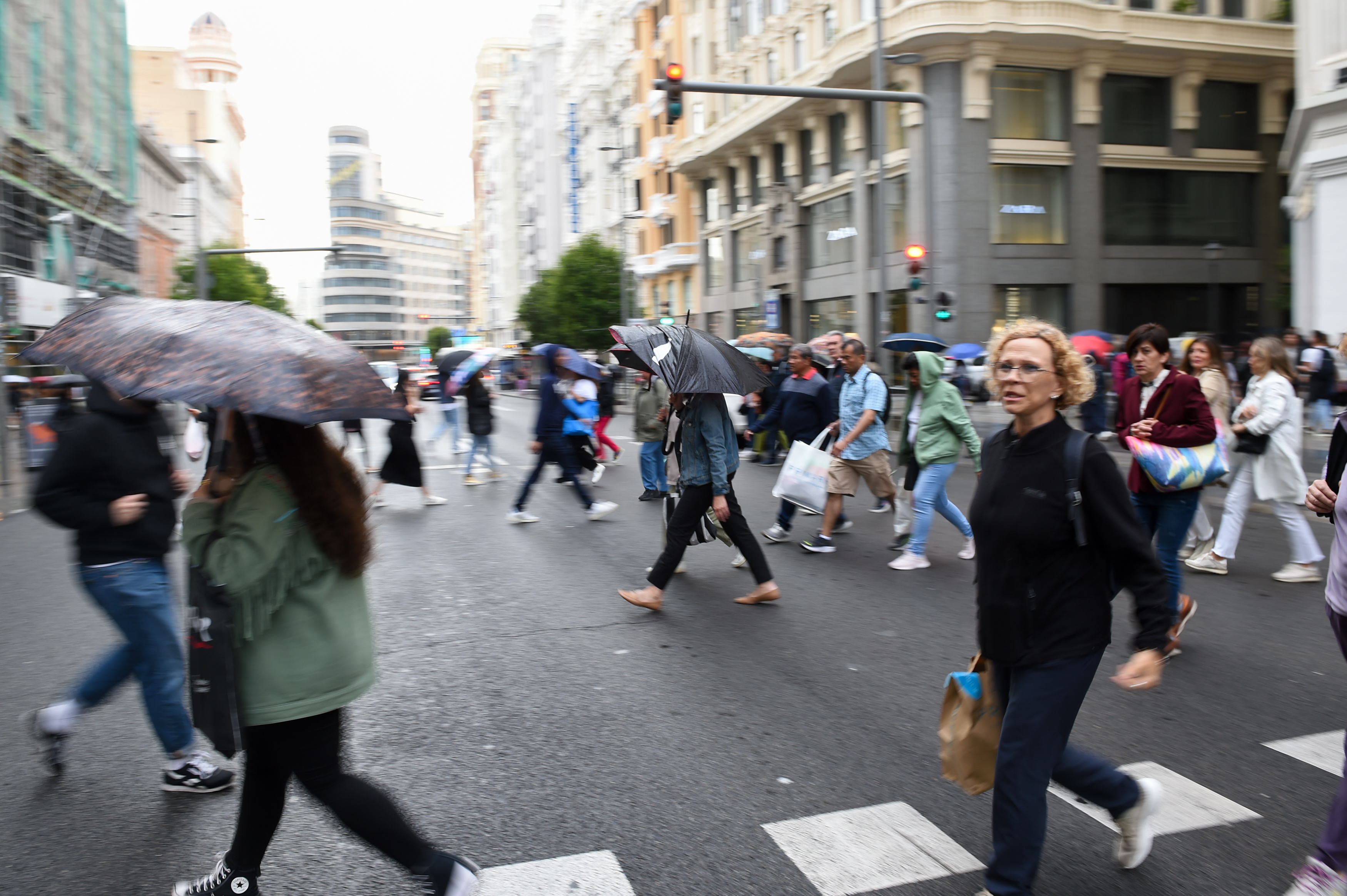 Varias personas pasean bajo la lluvia por la Gran Vía de Madrid. (Gustavo Valiente/Europa Press)