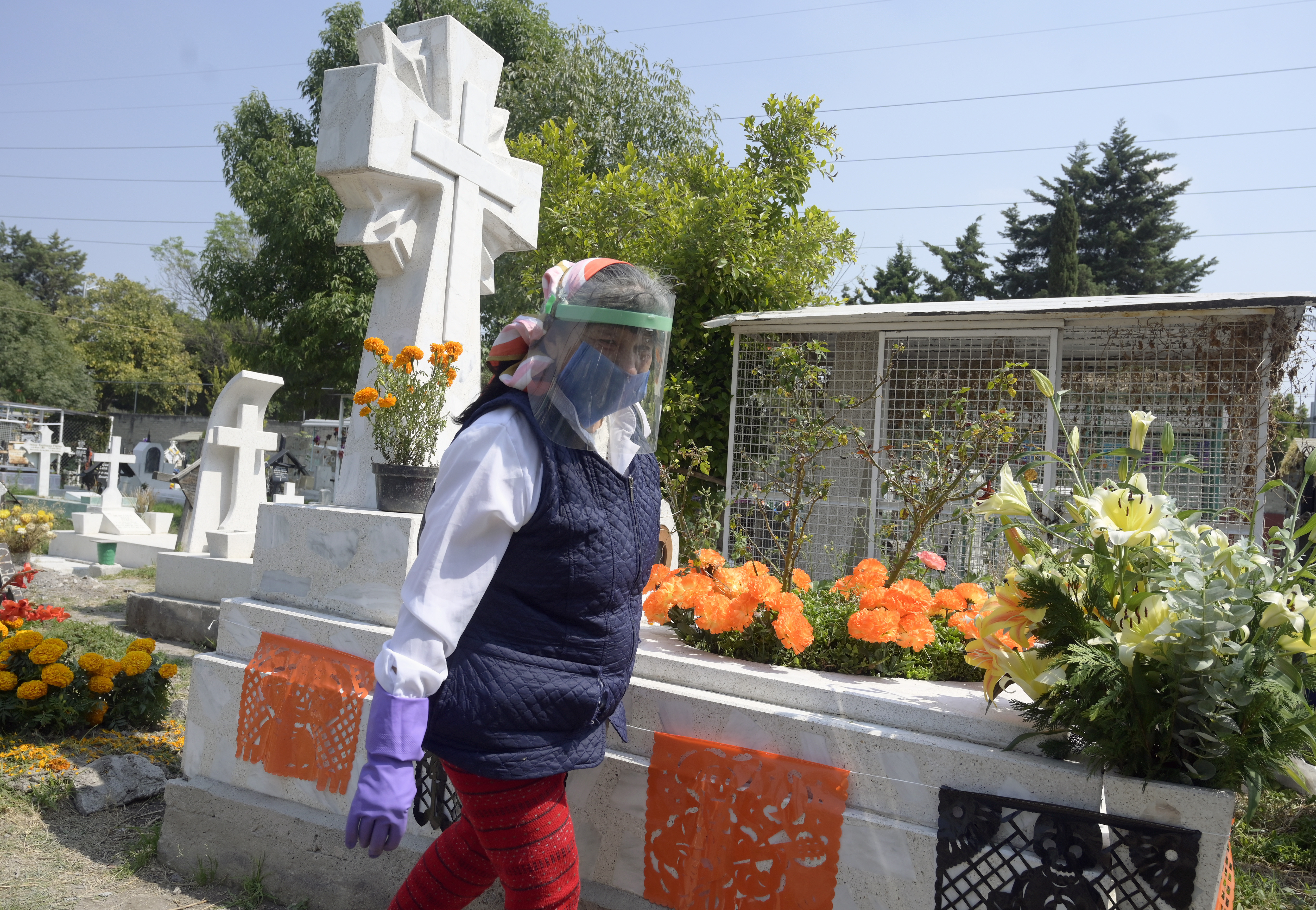 Una mujer visita la tumba de un familiar antes del Día de Muertos en el Panteón San José, en la Ciudad de México el 28 de octubre de 2020.