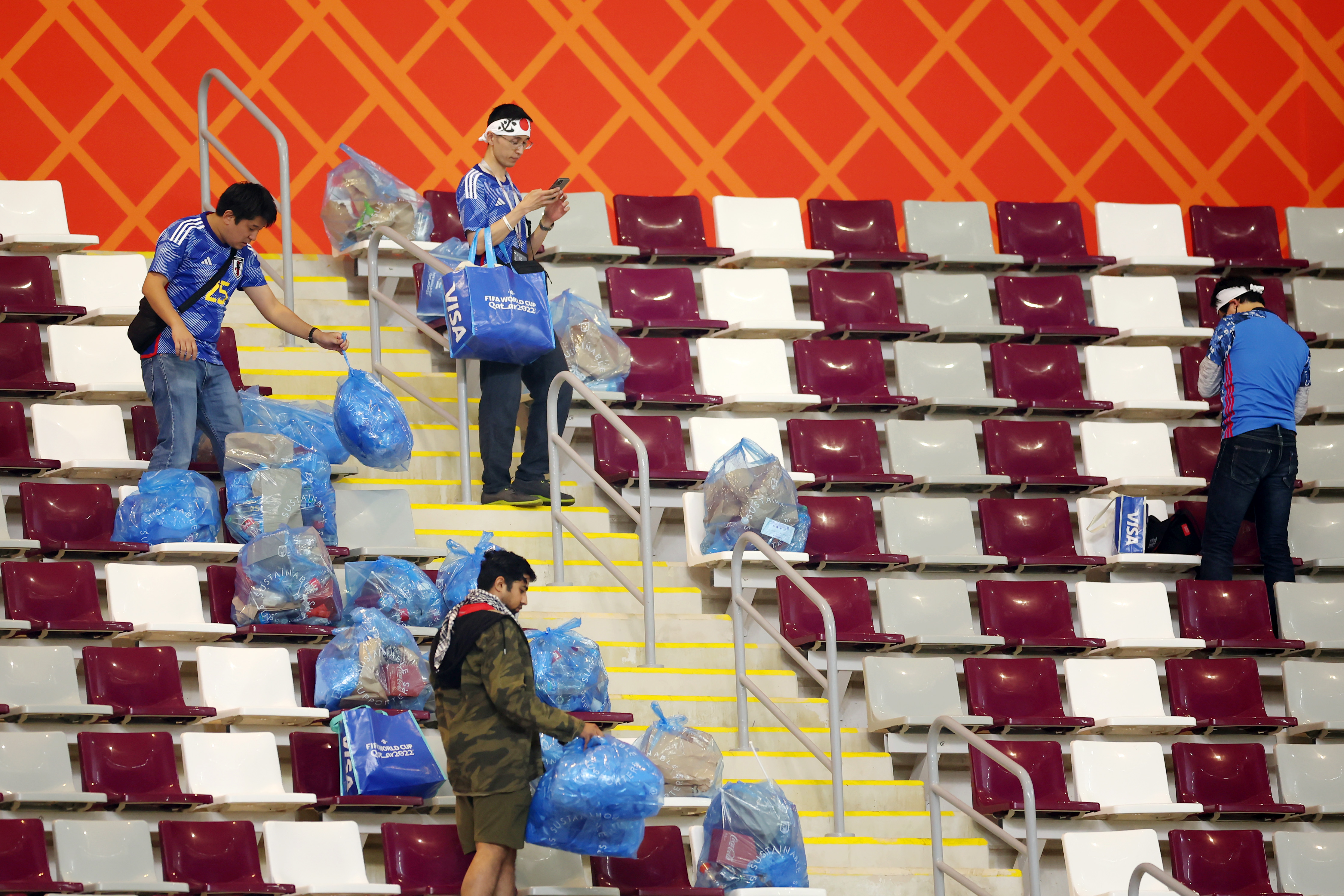 Los hinchas de Japón limpian el Khalifa International Stadium tras la victoria sobre Alemania (Foto: Alex Grimm/Getty Images)