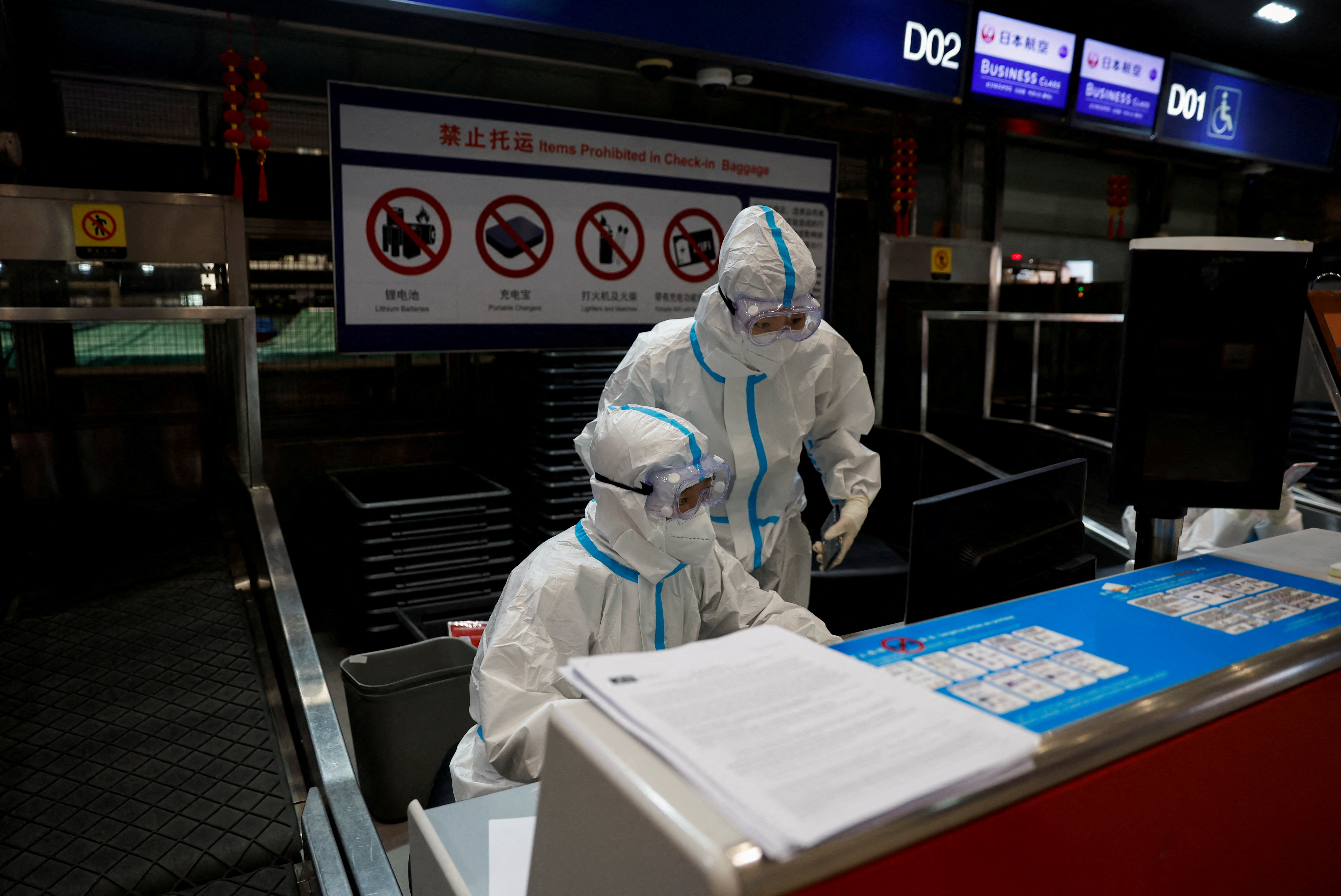 FOTO DE ARCHIVO: El personal de la aerolínea usa equipo de protección personal (EPP) para protegerse contra la enfermedad por coronavirus (COVID-19) mientras trabajan en el aeropuerto internacional de Beijing Capital en Beijing, China, el 13 de marzo de 2022. REUTERS/Soe Zeya Tun/Foto de archivo
