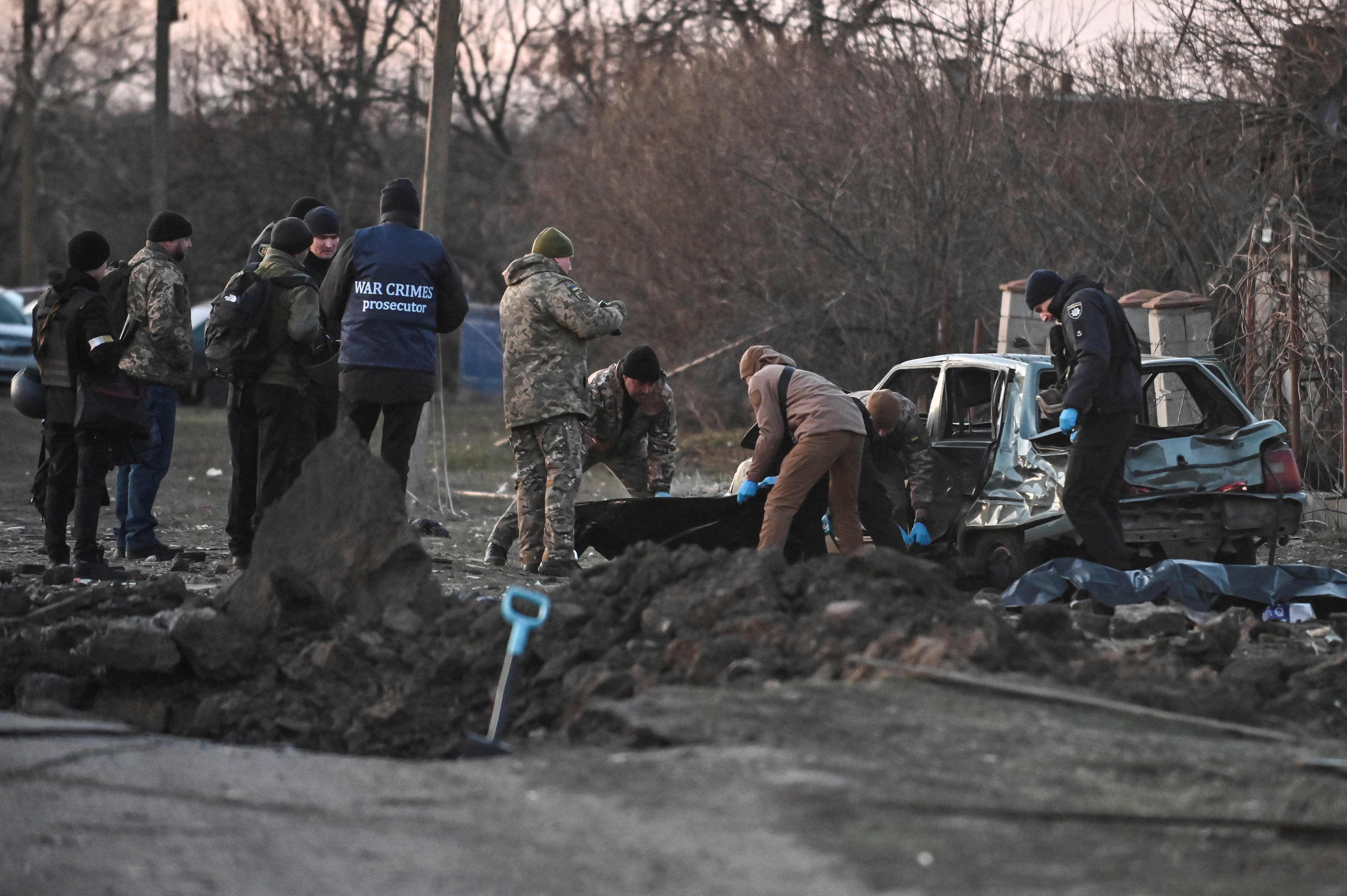 Los investigadores trabajan cerca de los cuerpos de los residentes locales asesinados por ataques con misiles de Rusia en Zaporizhzhia