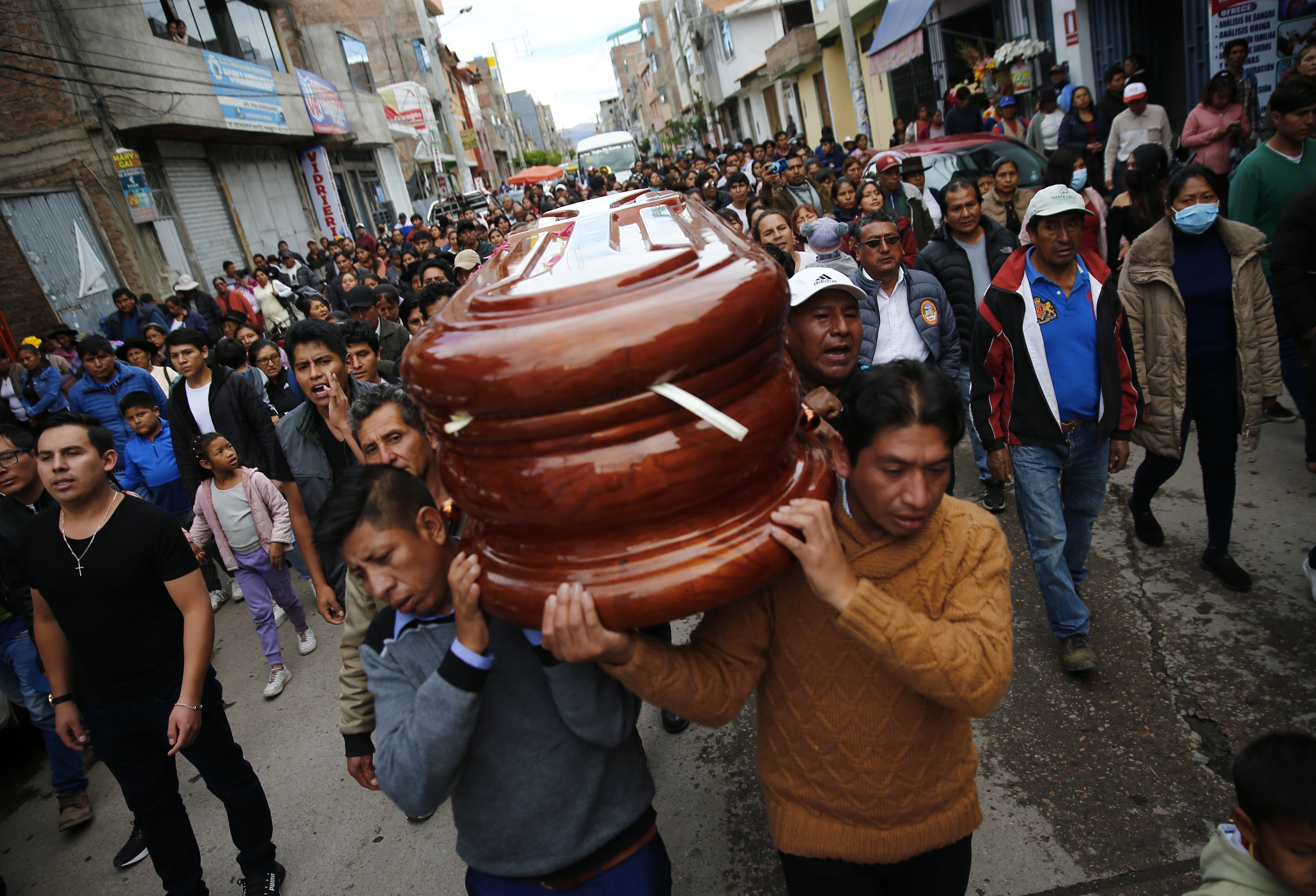 Un nutrido grupo de personas acompaña el féretro hasta el funeral del John Mendoza, de 34 años, que murió en las protestas contra la nueva presidenta Dina Boluarte, en Ayacucho, Perú, el sábado 17 de diciembre de 2022. (AP Foto/Hugo Curotto)