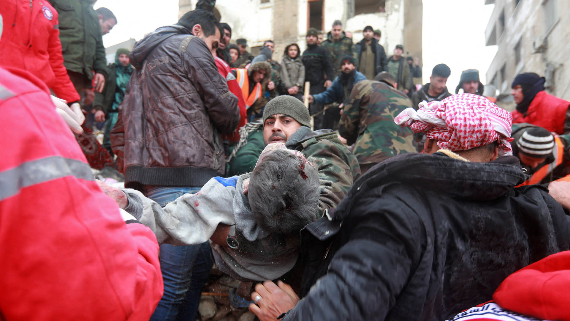 EDITORS NOTE: Graphic content / Syrian rescue teams carry a casualty picked up from the rubble after an earthquake in the government-controlled central Syrian city of Hama on February 6, 2023. - A 7.8-magnitude earthquake hit Turkey and Syria early on February 6, killing hundreds of people as they slept, levelling buildings and sending tremors that were felt as far away as the island of Cyprus, Egypt and Iraq. (Photo by LOUAI BESHARA / AFP)