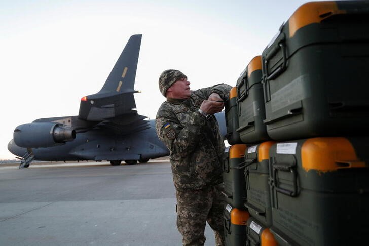A Ukrainian soldier unloads military aid provided by the Allies