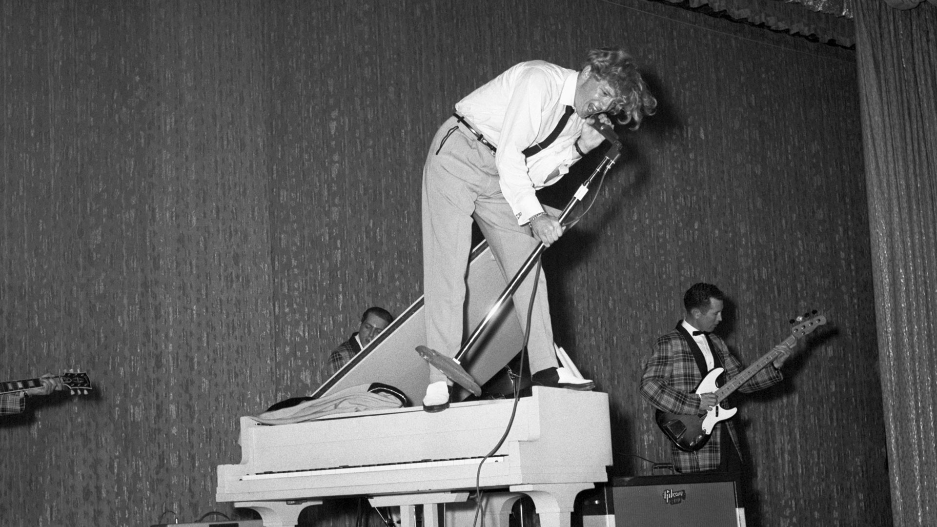 De pie sobre un piano, Jerry Lee Lewis ofrece una entusiasta actuación en el Café de París de Nueva York el 10 de junio de 1958 (Bettmann)