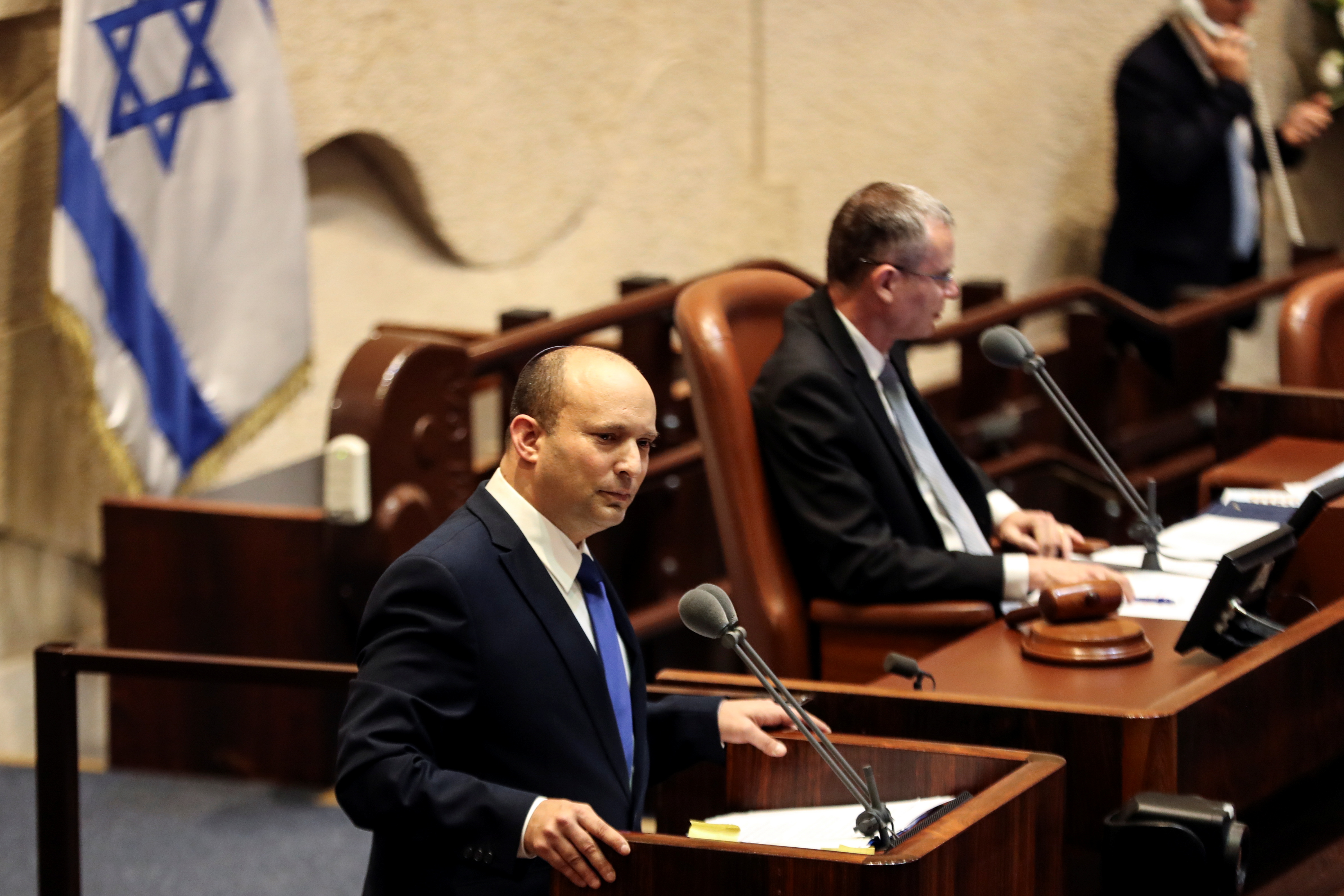 Naftali Bennett, primer ministro designado, habla en la Knesset, el parlamento de Israel, durante una sesión especial en la que se celebrará una votación de confianza para aprobar y jurar un nuevo gobierno de coalición, en Jerusalén el 13 de junio de 2021. REUTERS/Ronen Zvulun