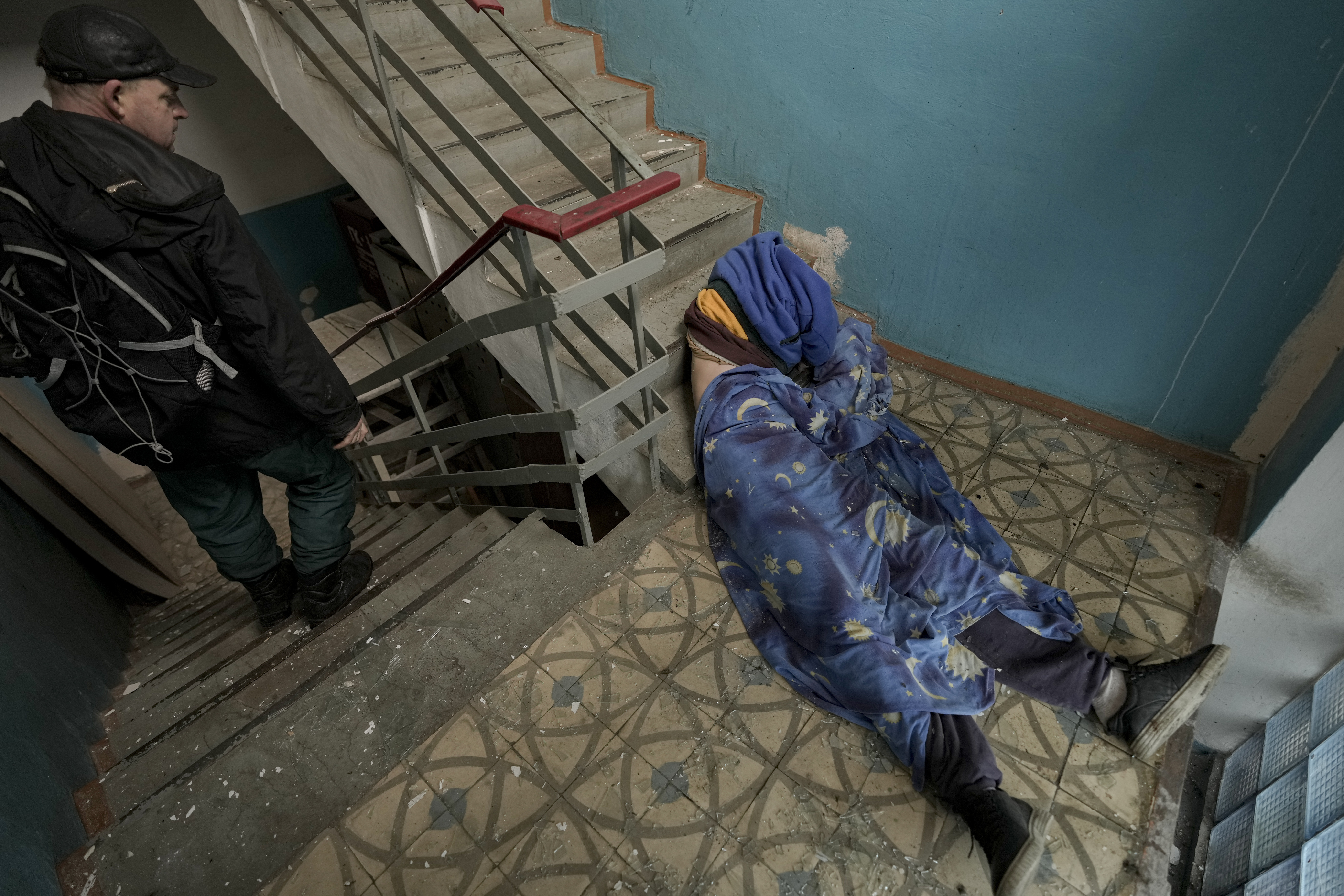 El cuerpo sin vida de un hombre se ve tumbado en la escalera de un edificio en Bucha, Ucrania, el domingo 3 de abril de 2022.  (AP Foto/Vadim Ghirda)