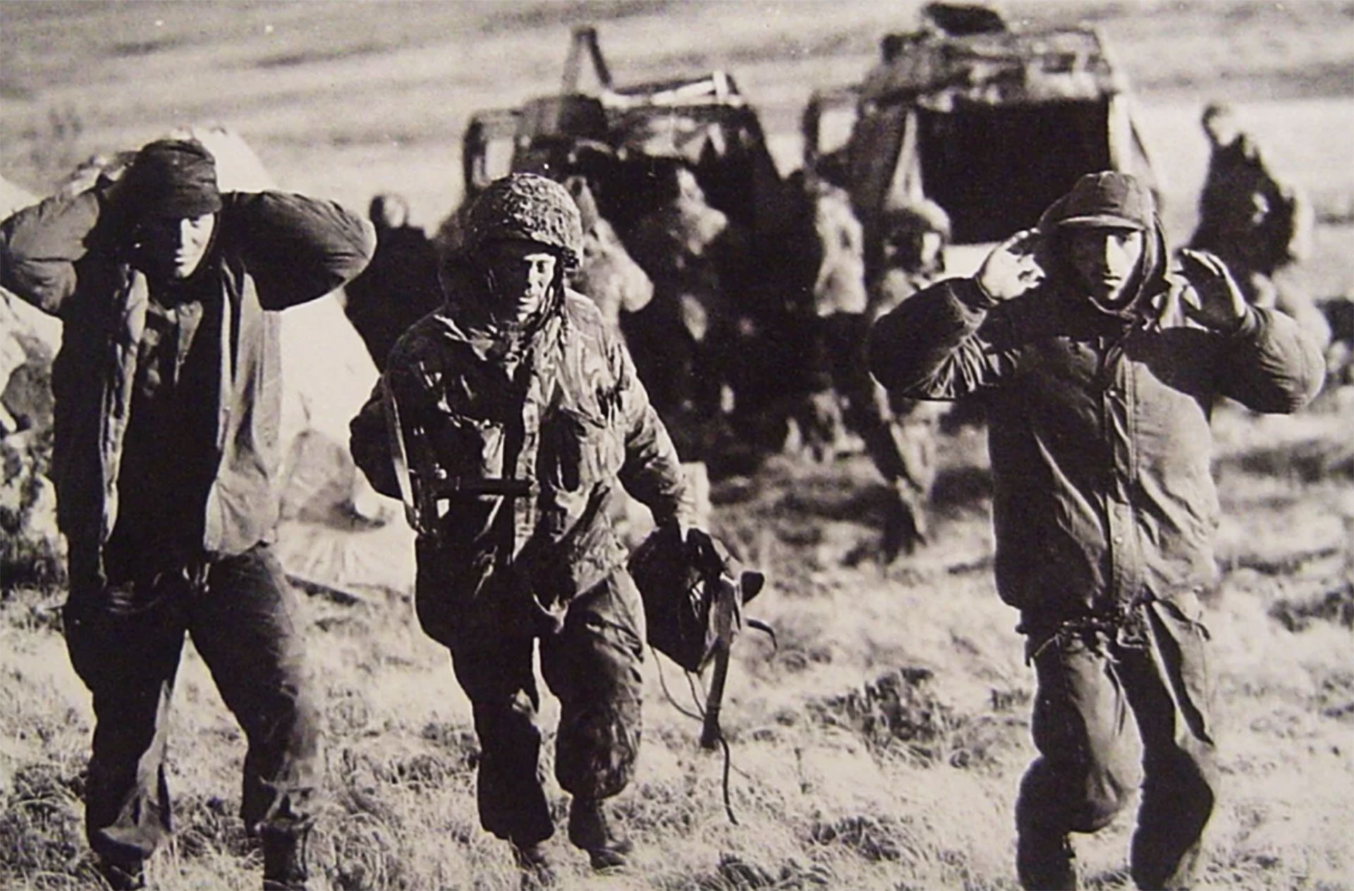 Un efectivo británico custodia a dos soldados argentinos luego de las últimas batallas cerca de Puerto Argentino