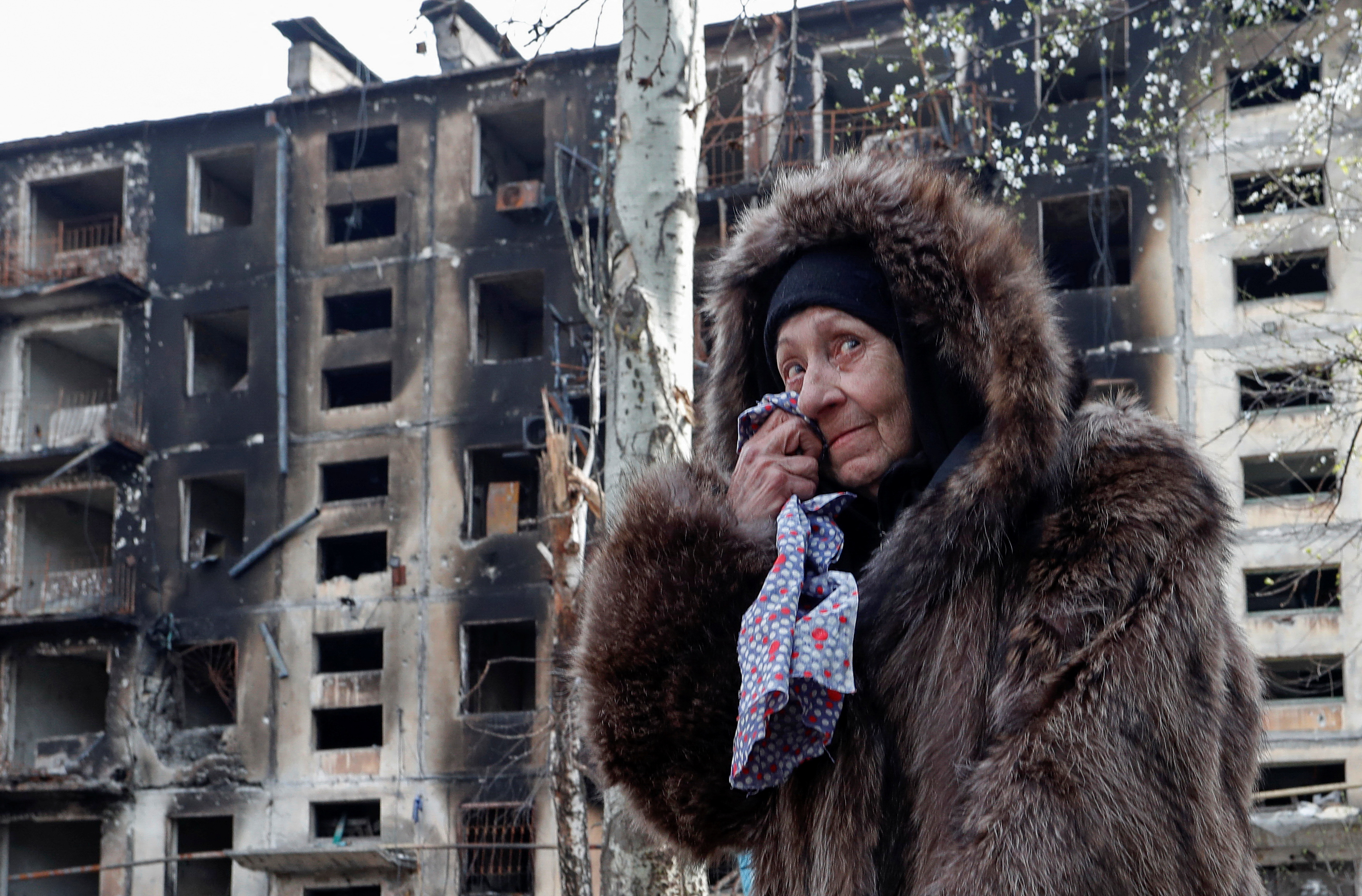 Un residente local reacciona mientras está parado cerca de un edificio residencial, que fue destruido durante el conflicto entre Ucrania y Rusia en la ciudad portuaria sureña de Mariupol, Ucrania, el 17 de abril de 2022. (REUTERS/Alexander Ermochenko)