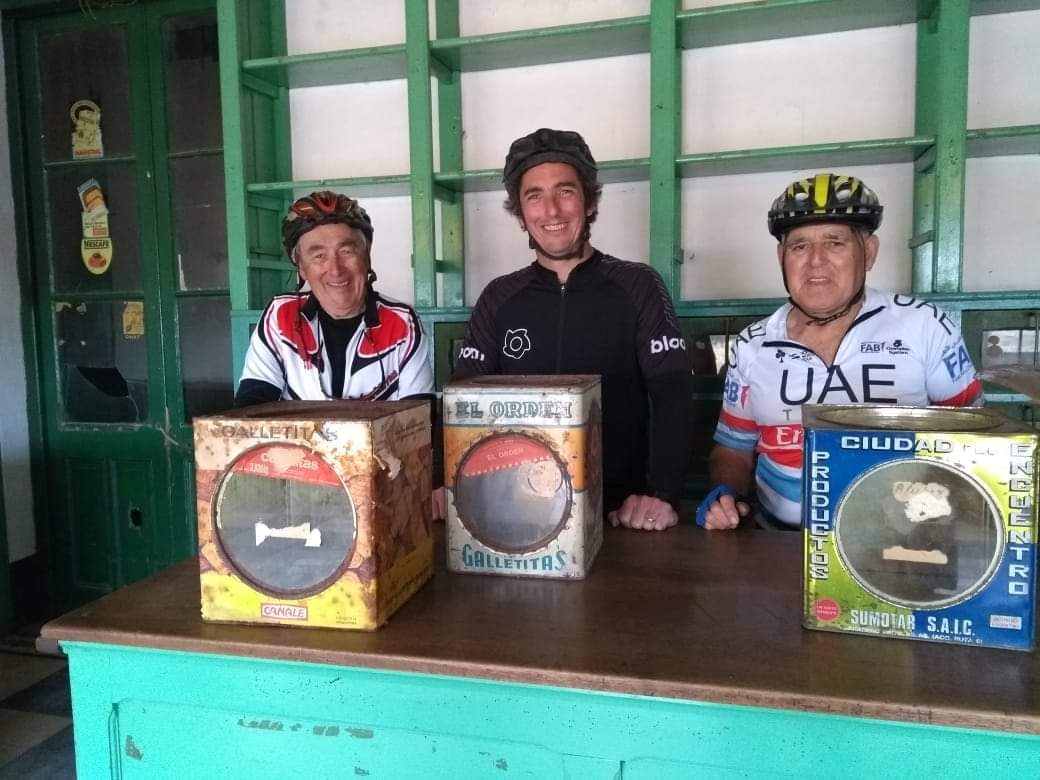 Los ciclistas que llegaron hasta El Pensamiento posan con las latas de galletitas que quedaron abandonadas en el almacén