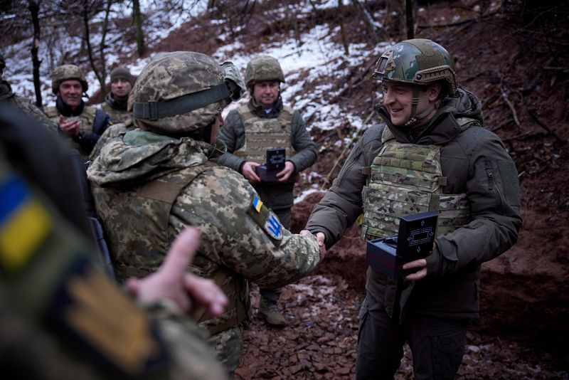 El presidente de Ucrania, Volodymyr Zelensky, saluda a efectivos en posiciones de combate cerca de la zona de separación con rebeldes apoyados por Rusia en la región de Donetsk el 6 de diciembre de 2021 (REUTERS)