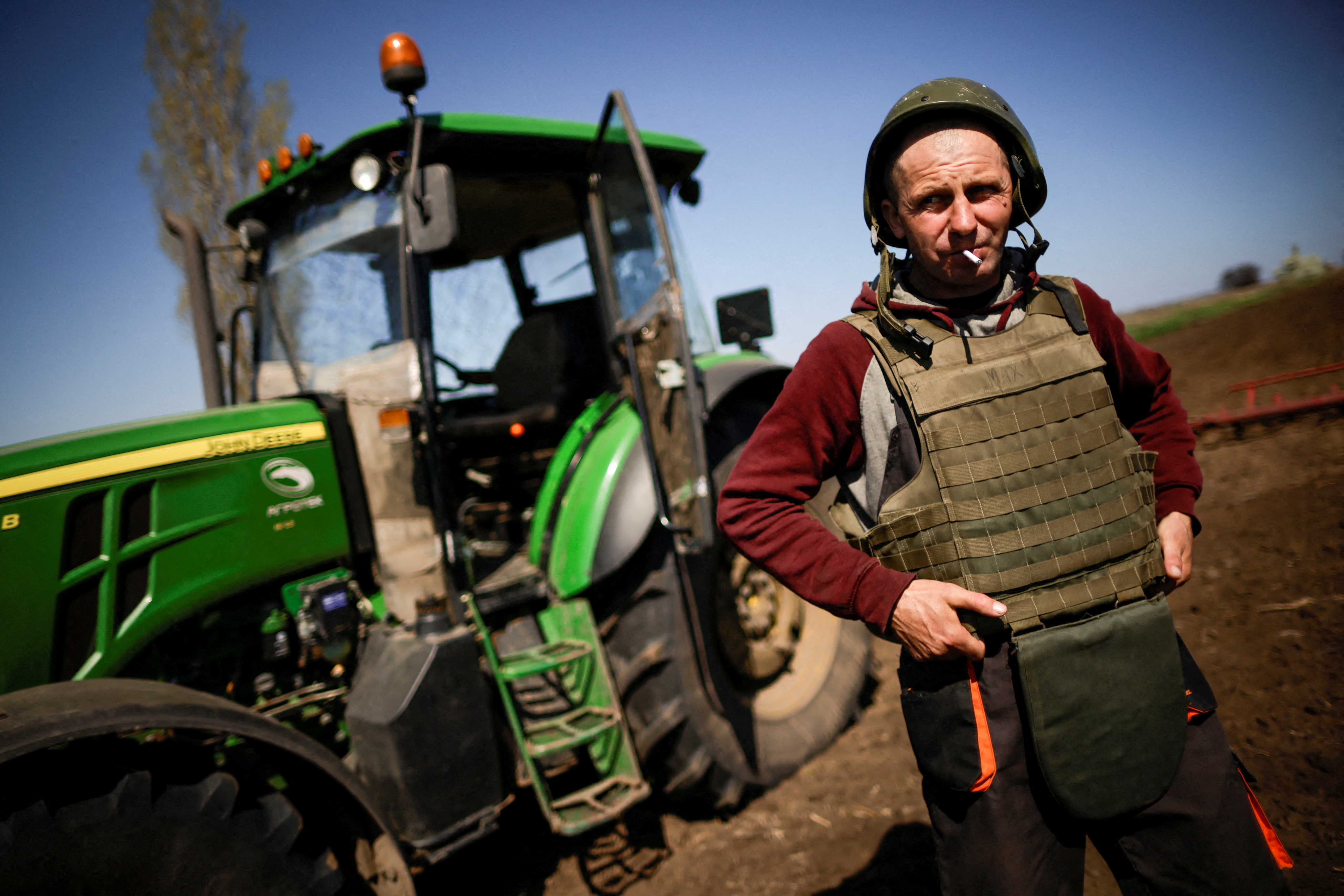 Un agricultor de la región ocupada de Zaporizhzhia sembrando en su campo con casco y chaleco antibalas por temor a los ataques que ahora pueden provenir de todos los bandos. (REUTERS/Ueslei Marcelino).