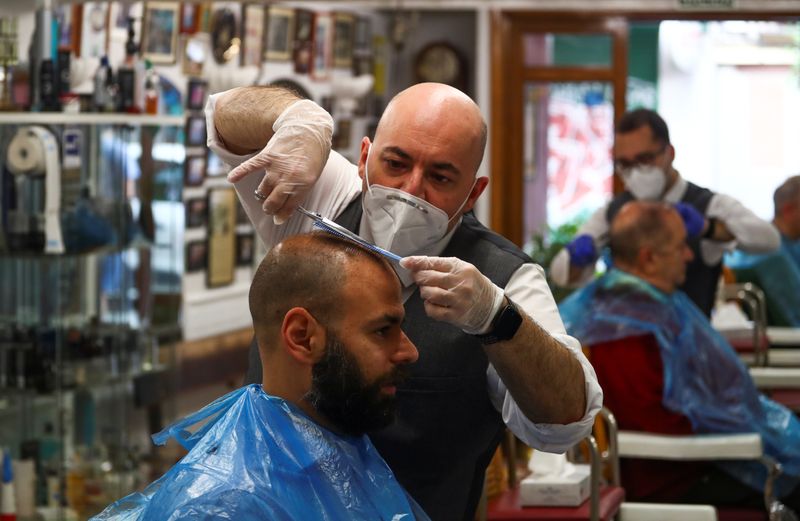 Un peluquero trabaja en su local de Madrid bajo protocolo de seguridad