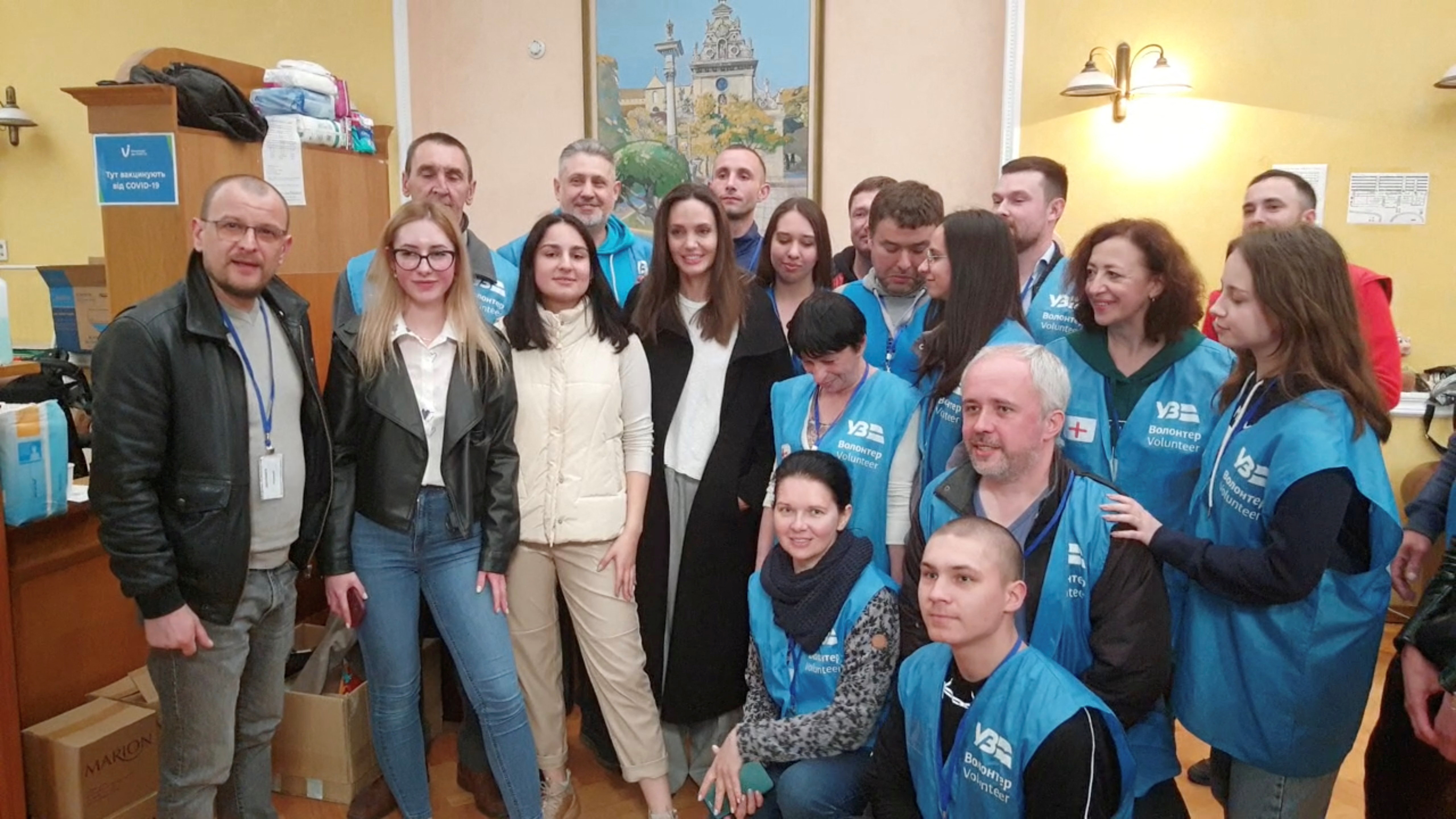 Jolie posa junto a grupo con voluntarios mientras visita la principal estación de tren de Lviv este 30 de abril de 2022 (REUTERS)