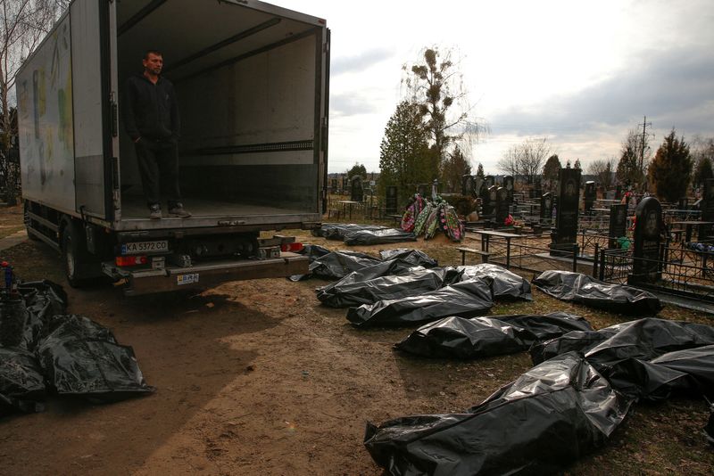 Un empleado del servicio funerario mira los cuerpos de los civiles, mientras continúa el ataque de Rusia contra Ucrania