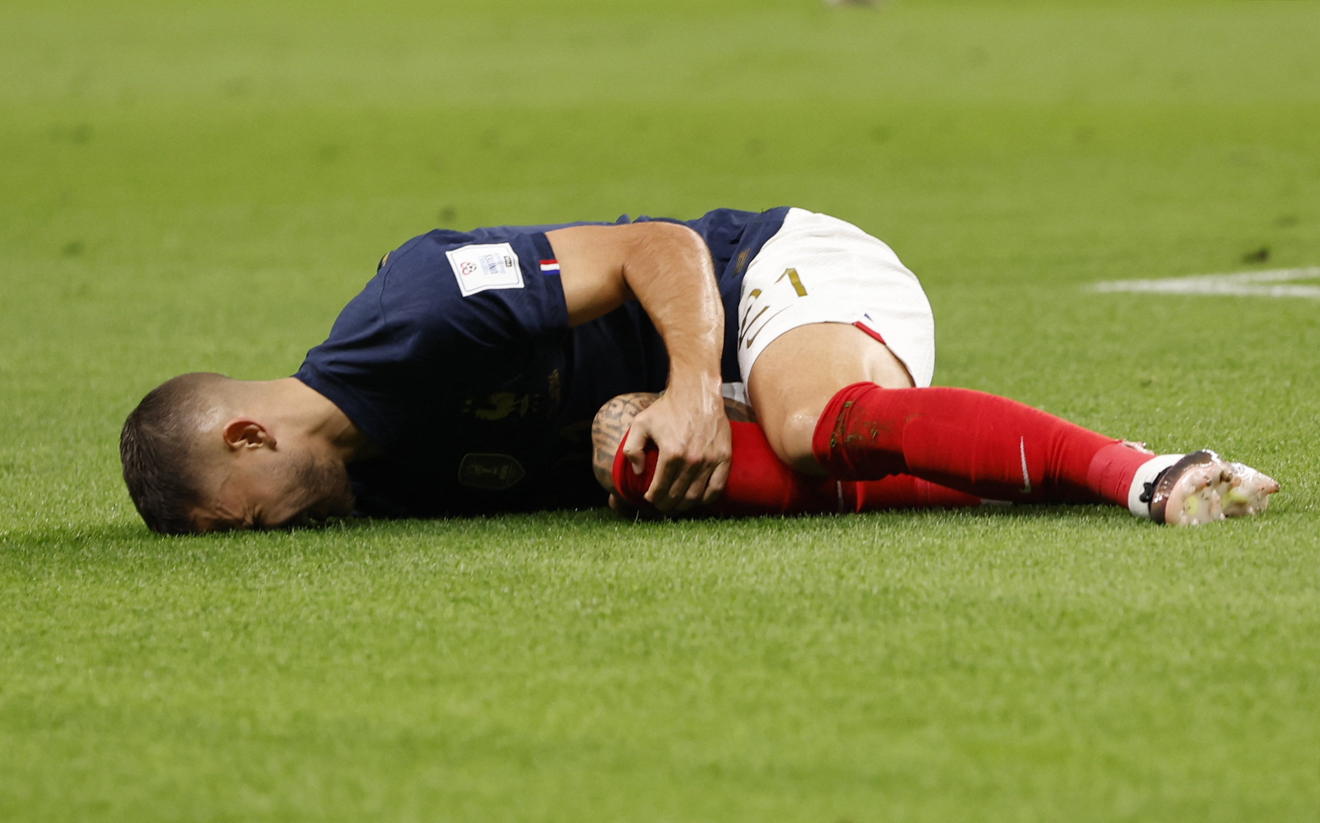 Lucas Hernández se toma la rodilla tras caer lesionado en el partido ante Australia, justo en la jugada del gol (REUTERS/Issei Kato)