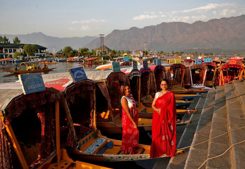 FOTO DE ARCHIVO: Turistas posan en "Shikaras" o botes estacionados a orillas del lago Dal en Srinagar, India, 5 de abril de 2022. REUTERS/Danish Ismail