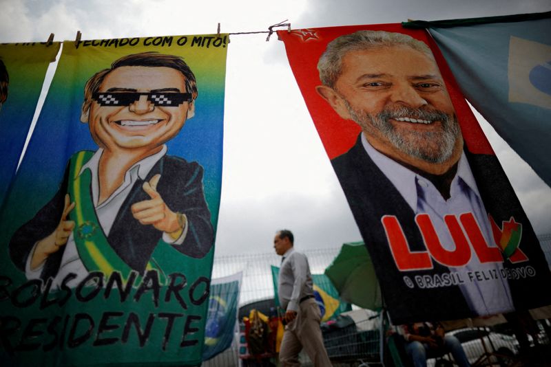 FOTO DE ARCHIVO: Un hombre camina junto a materiales de campaña presidencial del expresidente de Brasil Luiz Inácio Lula da Silva y del presidente Jair Bolsonaro, en Brasilia, Brasil (Reuters)