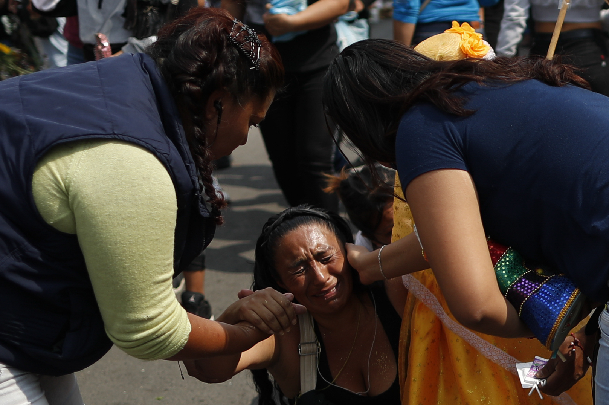 Un transeúnte, a la derecha, se detiene para ofrecer consuelo a Victoria Moreno, de 43 años, mientras lucha por llegar de rodillas al altar de la Santa Muerte (Foto: AP / Rebecca Blackwell)