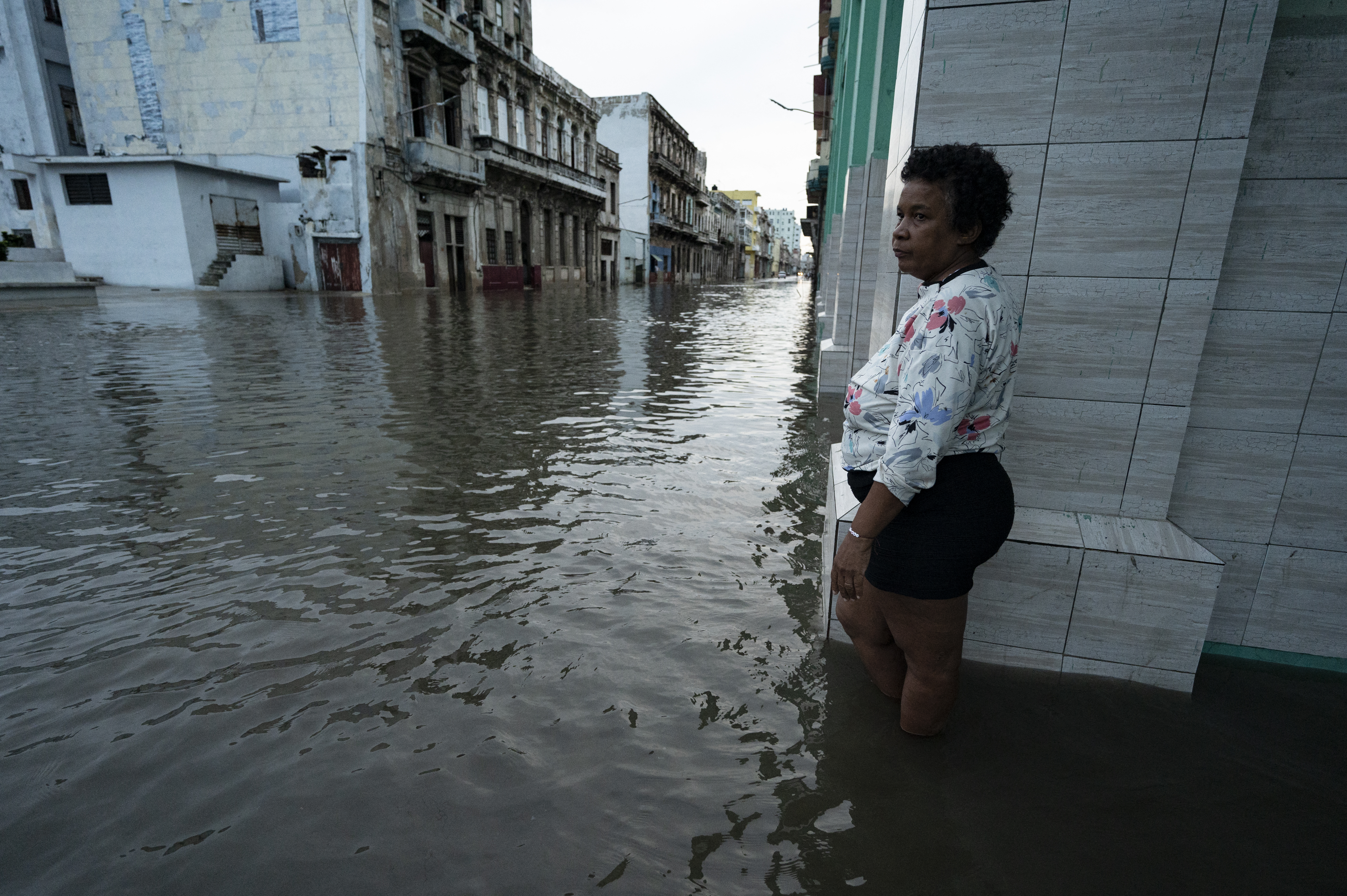 A woman stands on a flooded street in Havana, on September 28, 2022, after the passage of hurricane Ian. - Cuba exceeded 12 hours this Wednesday in total blackout with "zero electricity generation" due to failures in the links of the national electrical system (sen), after the passage of powerful Hurricane Ian. (Photo by YAMIL LAGE / AFP)