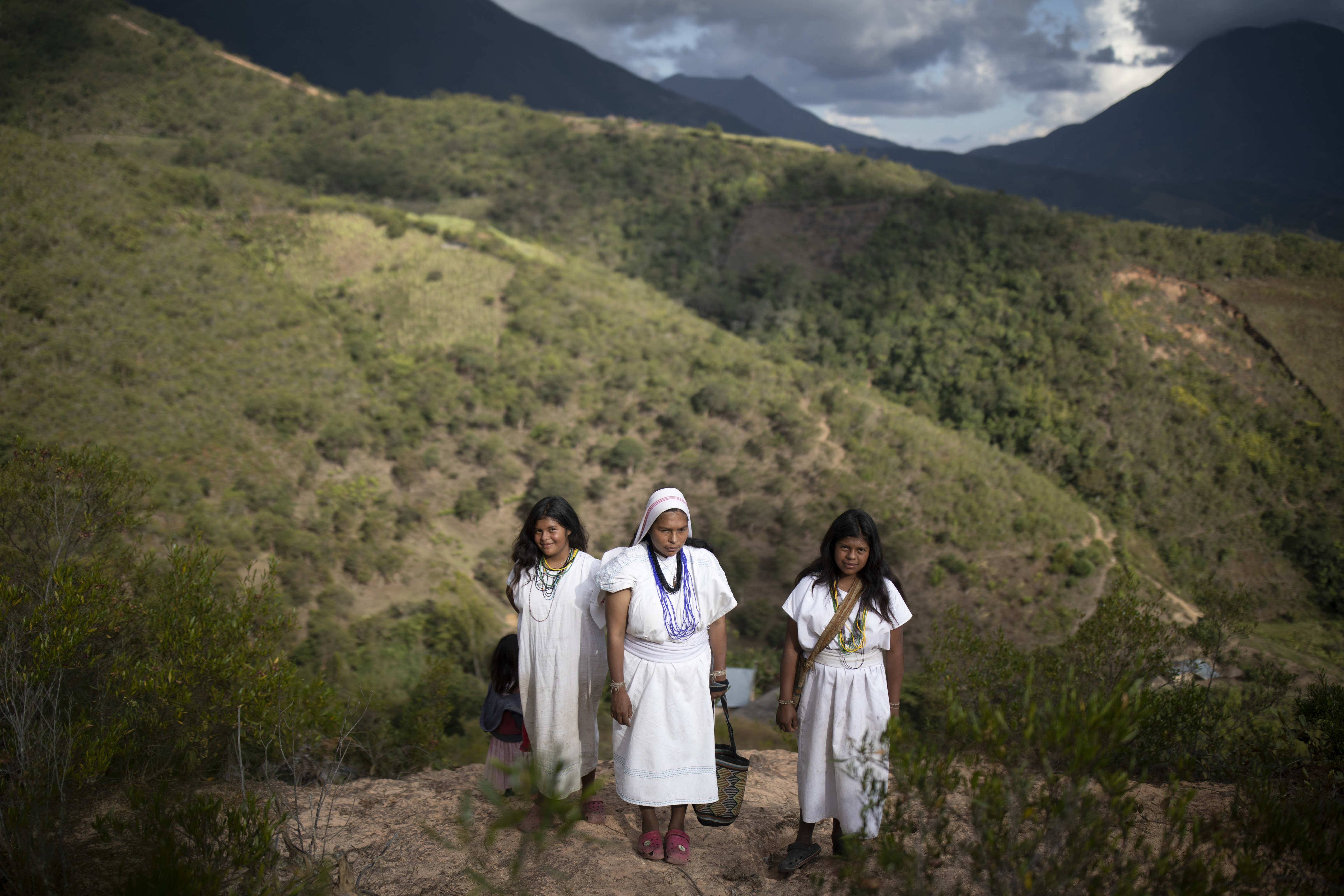 Las hermanas indígenas arhuaco Irene (izquierda), Lucía (centro) y Alba posan para una foto cerca de su casa en Nabusimake en la Sierra Nevada de Santa Marta, Colombia, el martes 17 de enero de 2023. (AP Foto/Iván Valencia)