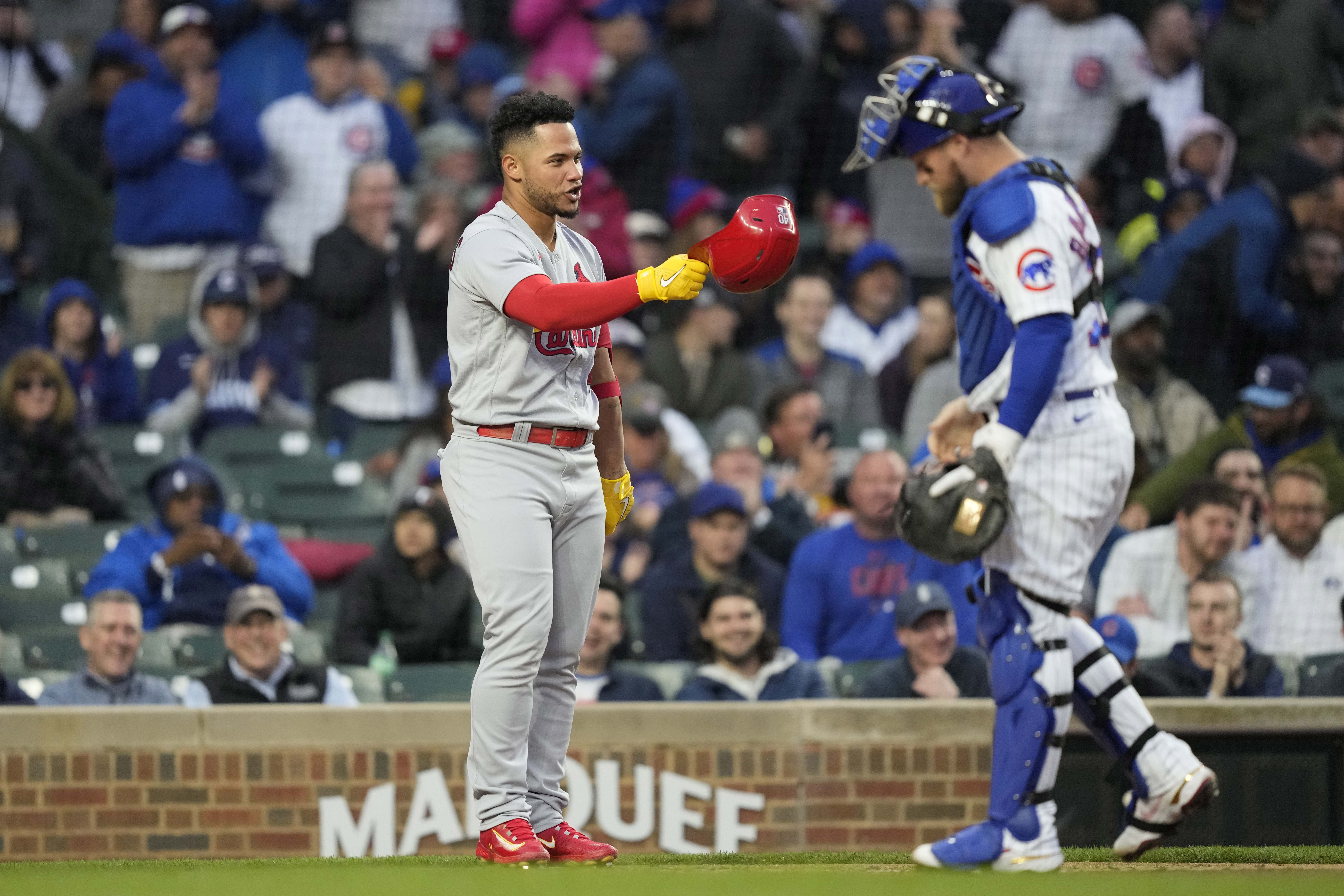 St. Louis Cardinals' Willson Contreras removes his helmet in front of Chicago Cubs catcher Tucker Barnhart during a game Monday, May 8, 2023. (AP Photo/Charles Rex Arbogast)
