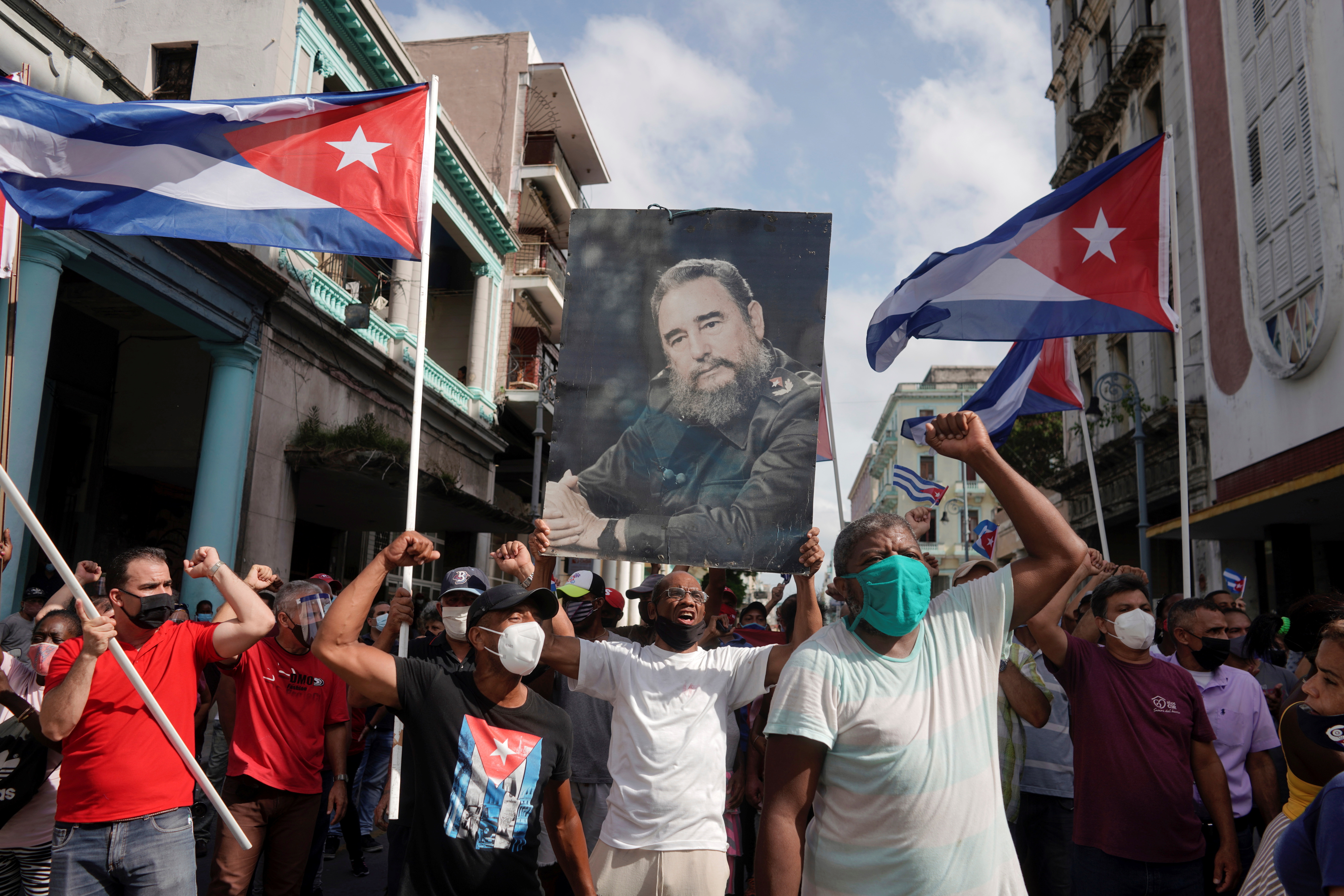 Simpatizantes del régimen sostienen una fotografía de Fidel Castro el 11 de julio de 2021 (REUTERS/Alexandre Meneghini)