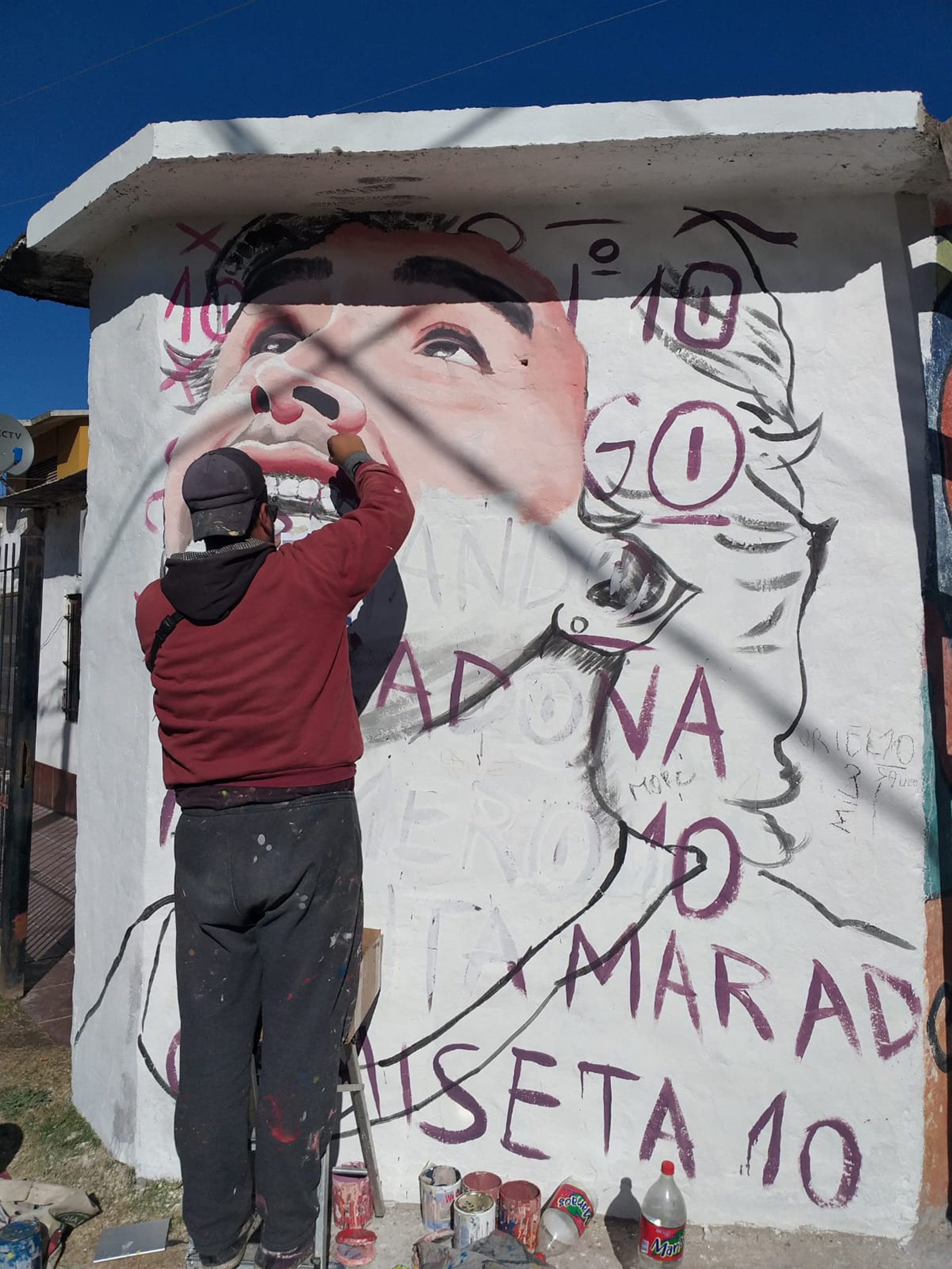 Santiago Mansilla en pleno proceso de pintado del mural de Maradona de Merlo