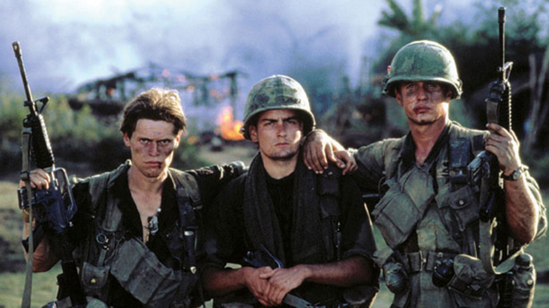Su primer gran papel en el cine fue en Pelotón de Oliver Stone. Aquí junto a Willem Dafoe y Tom Berenger, Pelotón ganó el Oscar a la mejor película. Un año después filmaría, también con Stone, Wall Street.  (c) Orion Pictures/ Courtesy: Everett Collection.
