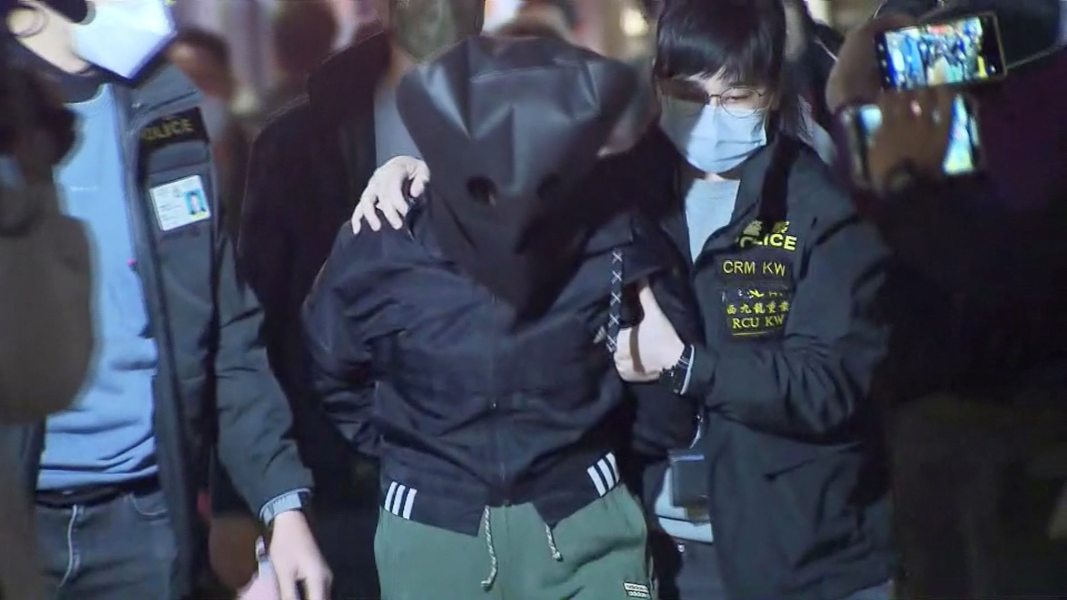 Oficiales de policía escoltan a un sospechoso de 47 años en relación con el asesinato de la modelo Abby Choi, de 28 años, en Hong Kong, China, el 26 de febrero de 2023 en esta captura de pantalla tomada de un video. TVB/ Folleto a través de REUTERS 