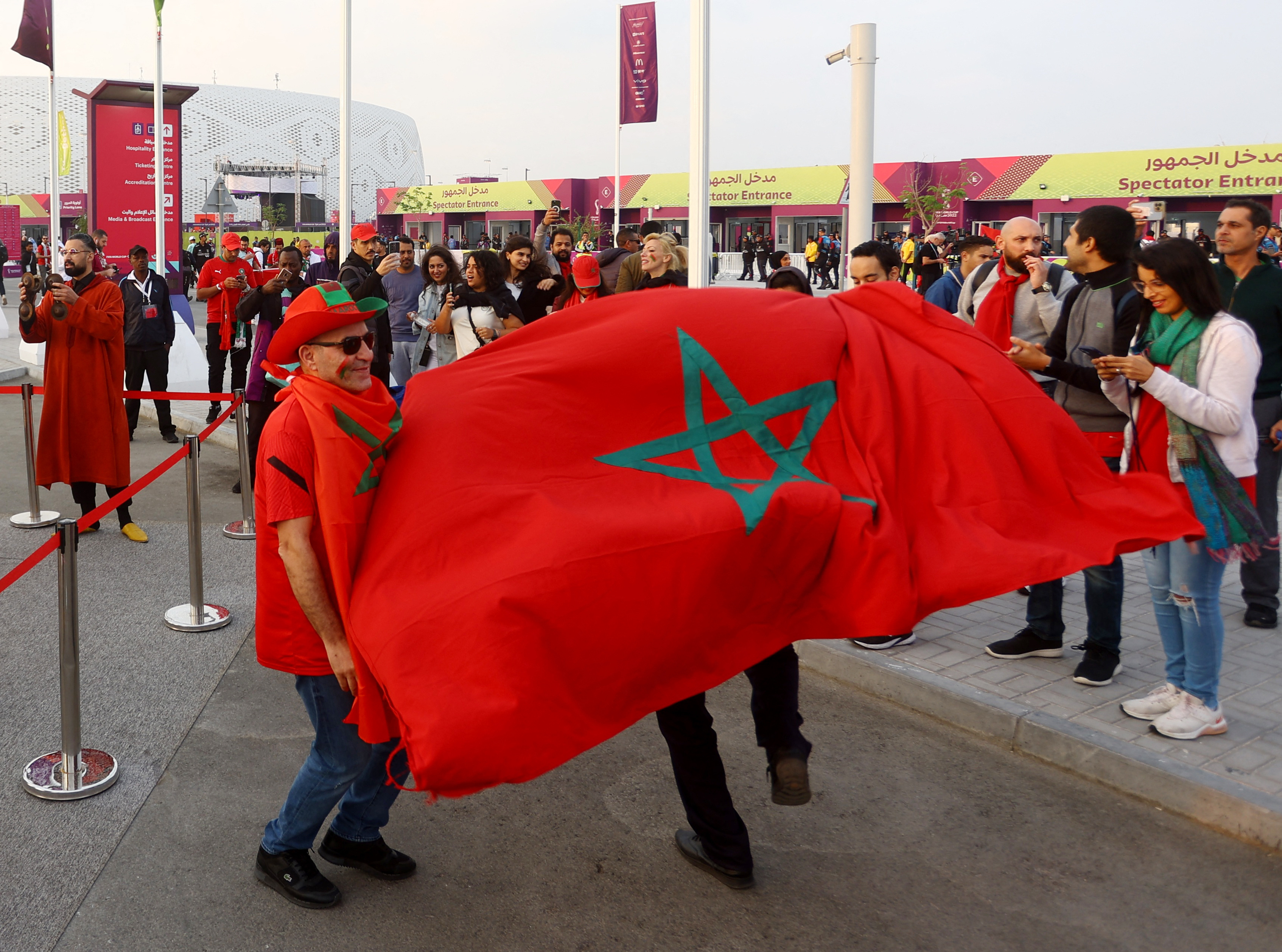 Fanáticos del seleccionados de Marruecos despliegan una bandera el país africano en las inmediaciones del estadio Al Thumama, en Qatar (REUTERS/Ibraheem Al Omari)