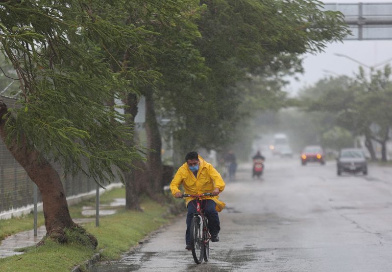 Un hombre viaja en su bicicleta bajo la lluvia. REUTERS/Lorenzo Hernandez