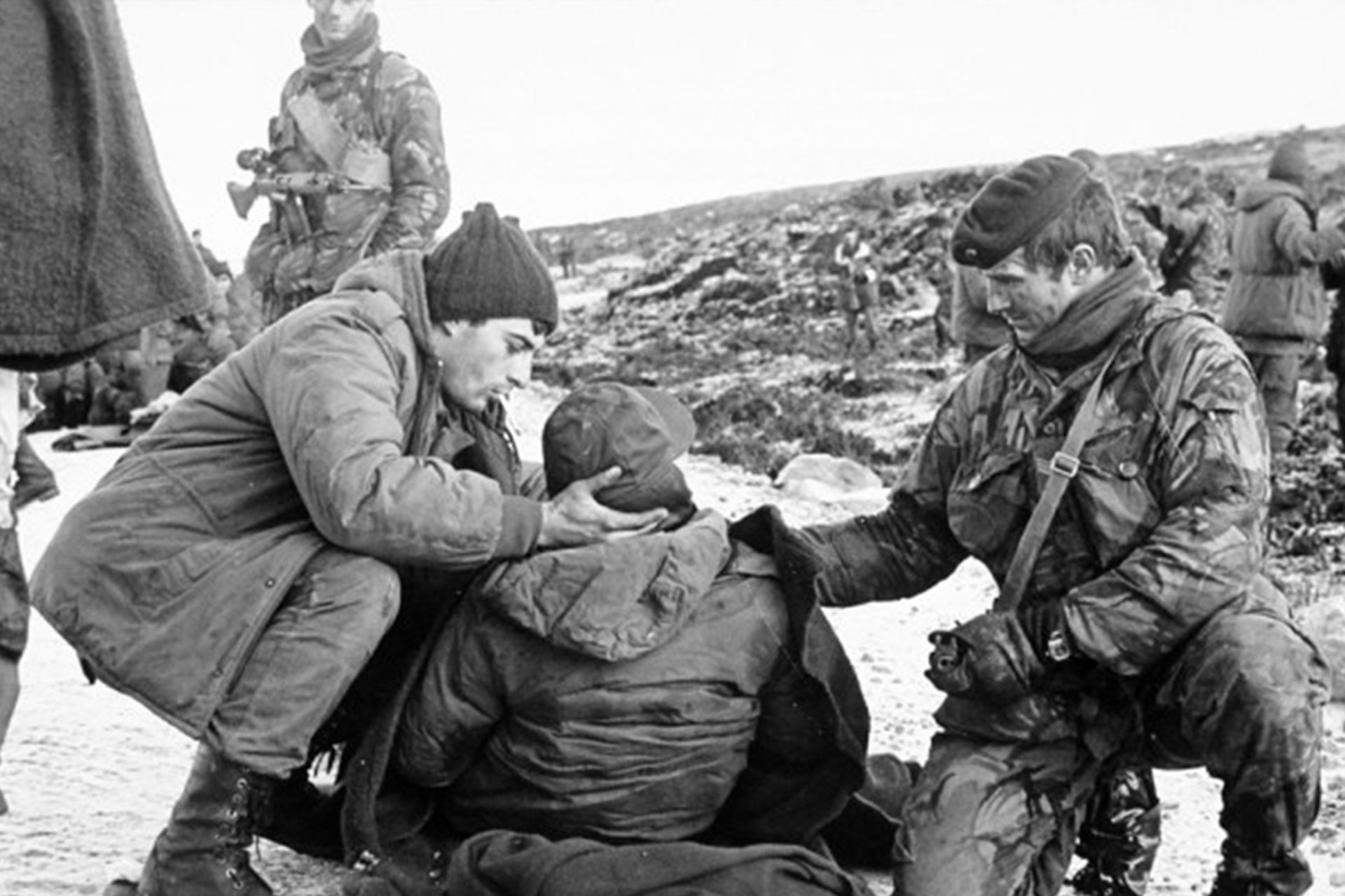 Foto tomada el 12 de junio de 1982 a los pies de Monte Harriet, luego de la batalla. Un marine inglés asiste a un soldado argentino herido. “Hubo respeto y cuidado por los heridos de ambos bandos”, dijo Lautaro Jiménez Corbalán