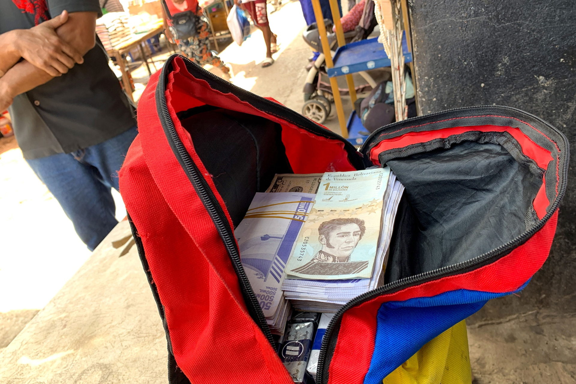 Un vendedor ambulante con una mochila de bolívares venezolanos es visto en un mercado público en Puerto la Cruz, Venezuela, el 14 de octubre de 2021. (Bloomberg por Manaure Quintero)