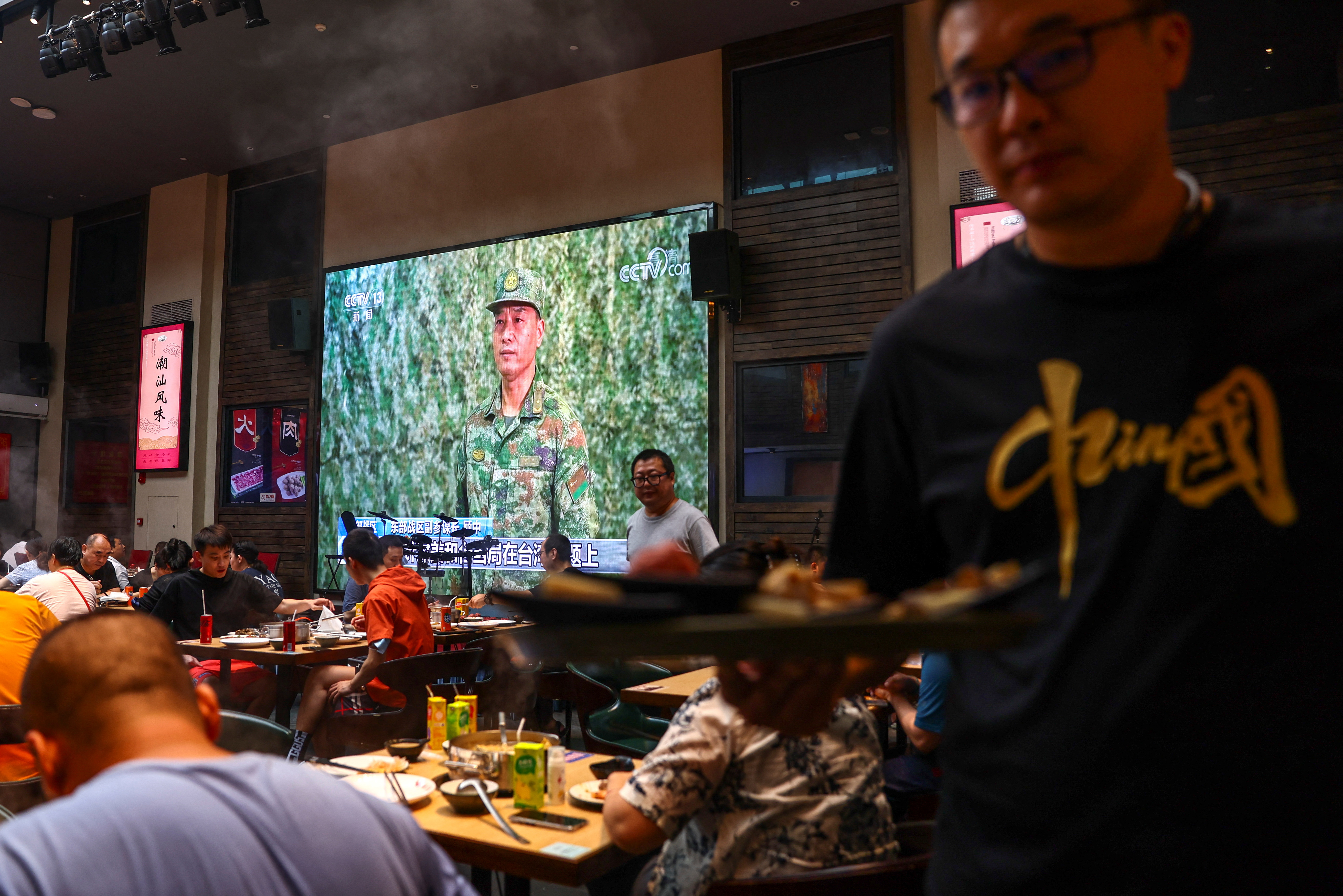 Transmisión de un mensaje del ejército chino en un restaurante de la capital (Reuters)