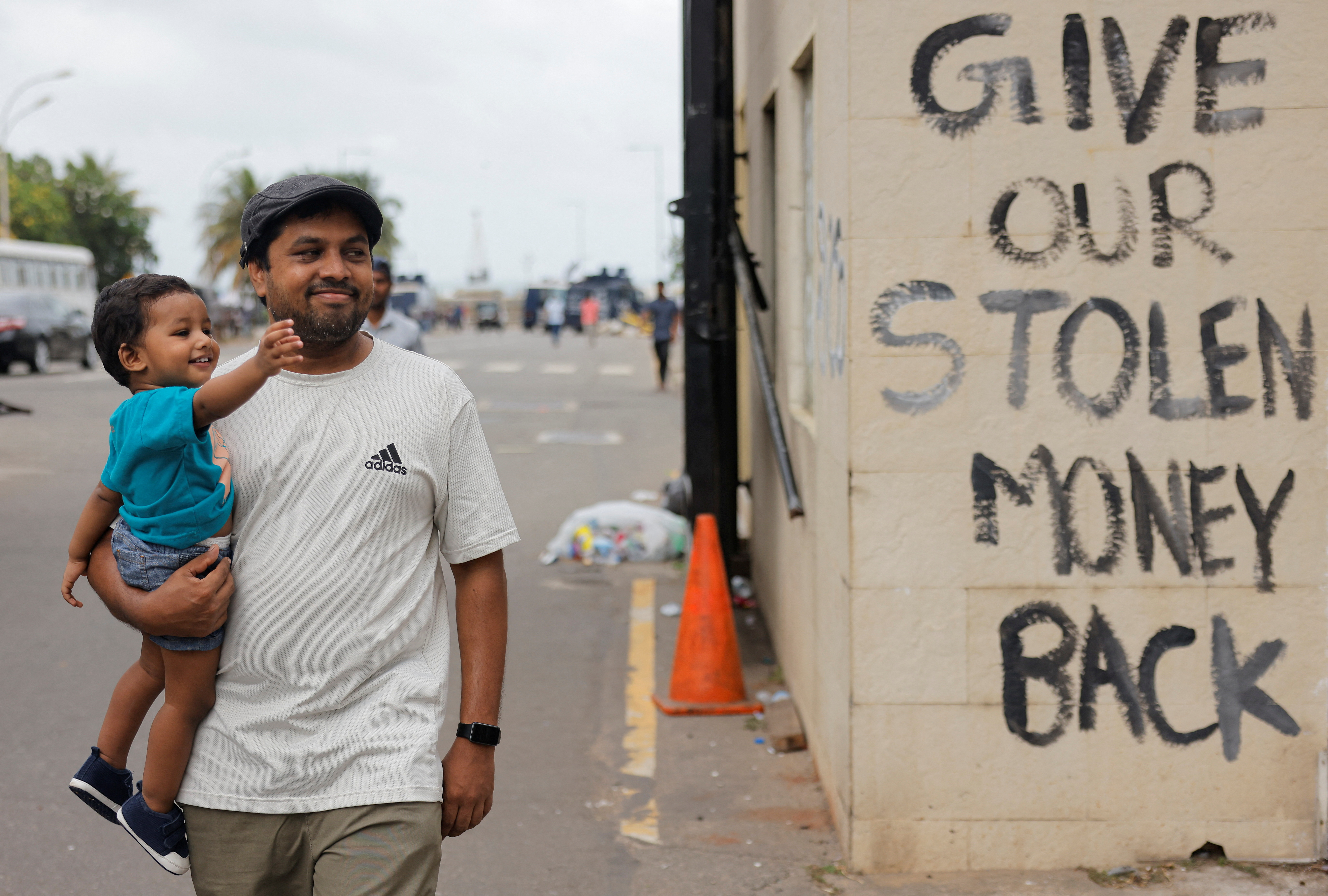 Un hombre pasa frente a un eslogan escrito en las paredes de una sala de seguridad cerca de la casa del presidente al día siguiente de que los manifestantes ingresaran al edificio, luego de que el presidente Gotabaya Rajapaksa huyera, en medio de la crisis económica del país, en Colombo, Sri Lanka. REUTERS/Dinuka Liyanawatte
