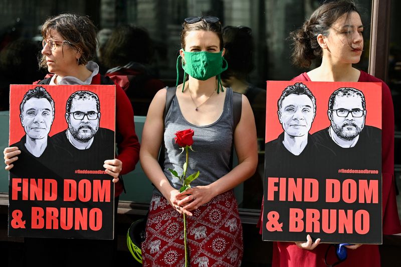 I manifestanti tengono cartelli e fiori per protestare contro la scomparsa del giornalista Dom Phillips e dell'attivista Bruno Araujo Pereira nella regione amazzonica, fuori dall'ambasciata brasiliana a Londra, in Gran Bretagna.  9 giugno 2022. REUTERS/Toby Melville