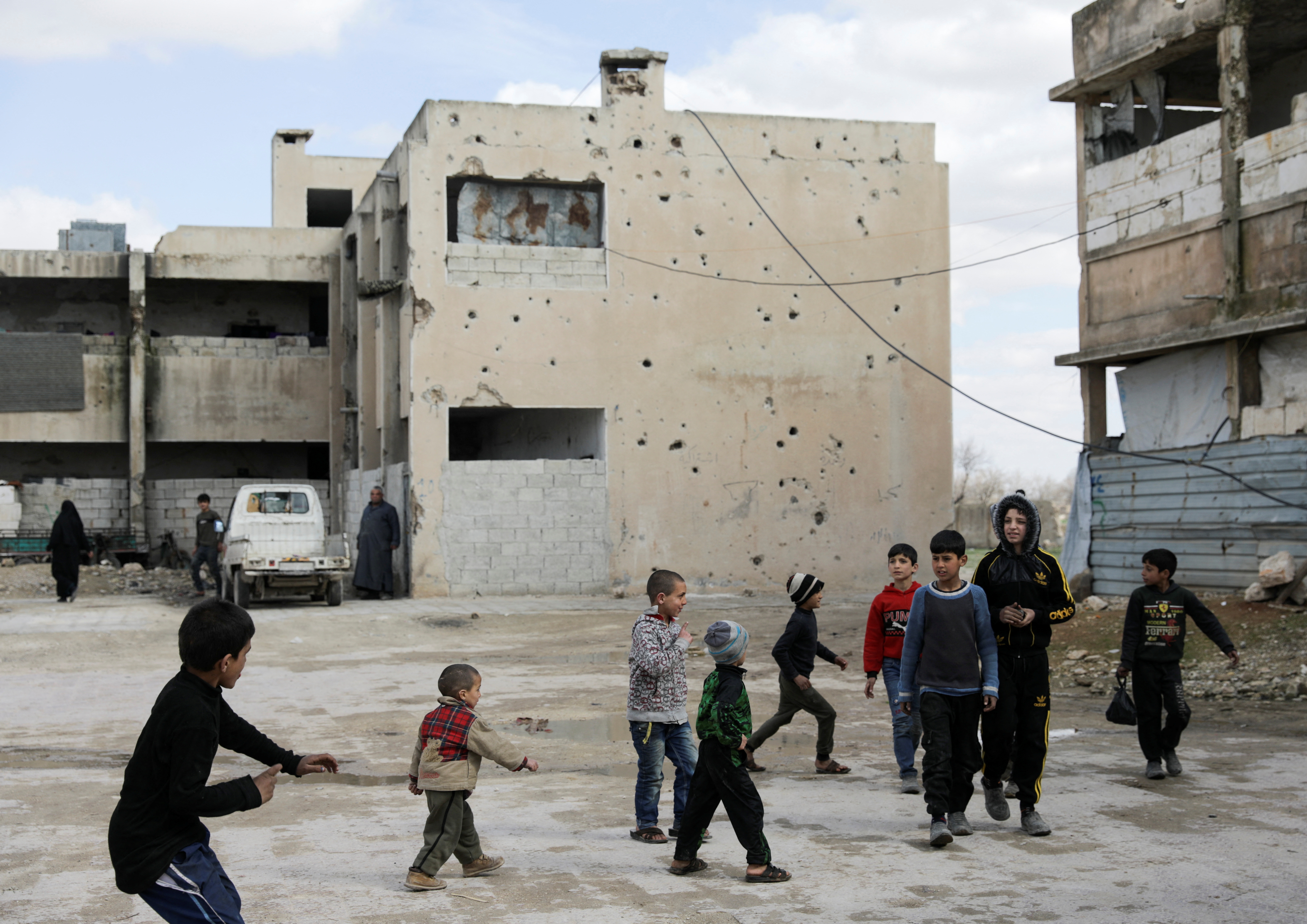 Unos niños juegan cerca de edificios dañados en la ciudad de Tadef, controlada por los rebeldes, en una línea de frente entre las fuerzas gubernamentales sirias respaldadas por Rusia y el territorio rebelde sirio respaldado por Turquía, en el norte de Siria el 4 de marzo de 2022. Foto tomada el 4 de marzo de 2022. REUTERS/Khalil Ashawi