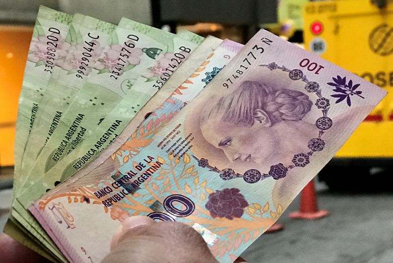 Foto de archivo: un hombre sostiene varios billetes de pesos argentinos en el centro financiero de Buenos Aires, Argentina.  30 ago, 2018. REUTERS/Marcos Brindicci