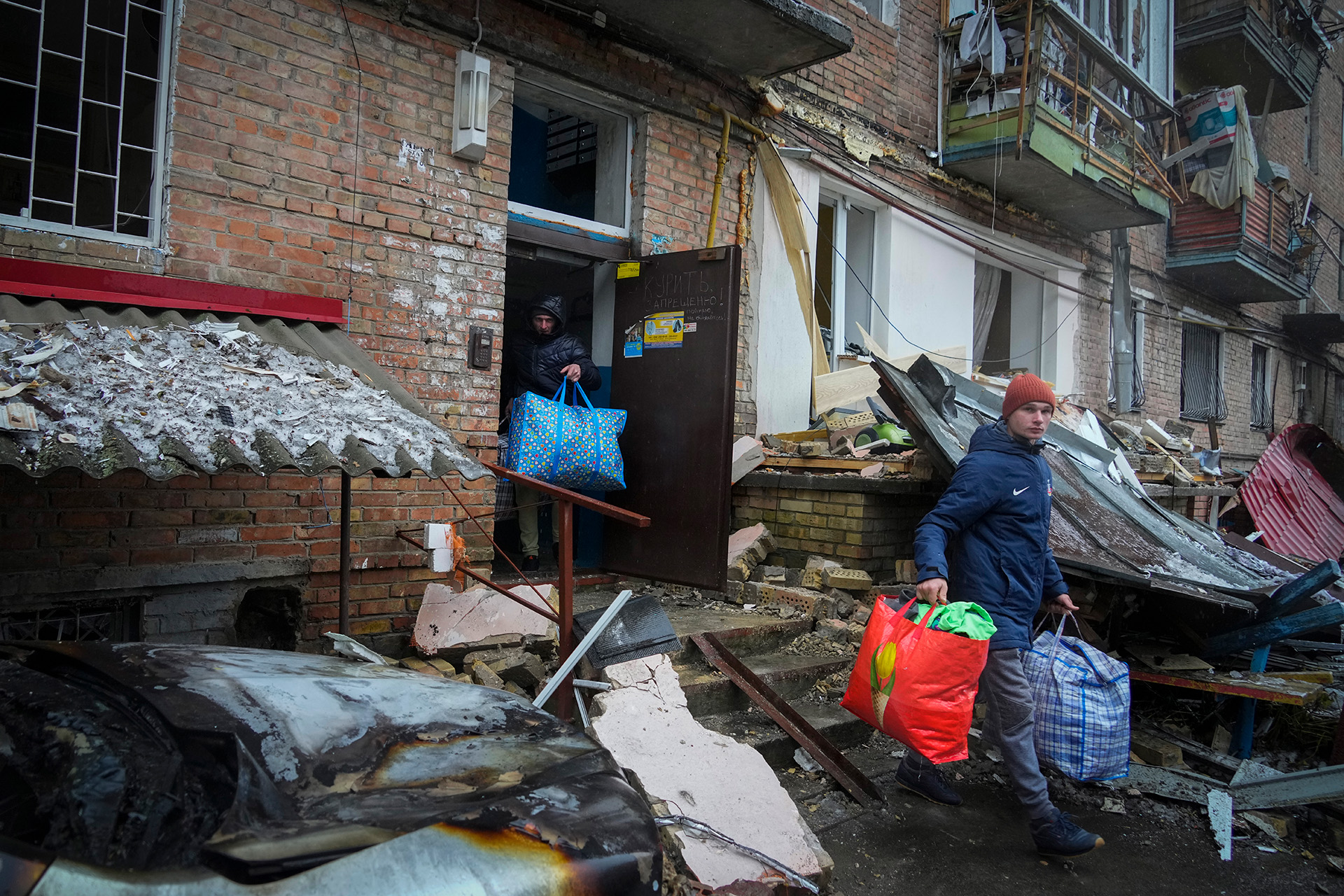 La gente recoge sus pertenencias de una casa dañada después del bombardeo ruso en la ciudad de Vyshgorod, en las afueras de la capital, Kiev, Ucrania, el jueves 24 de noviembre de 2022. (Foto AP/Efrem Lukatsky)