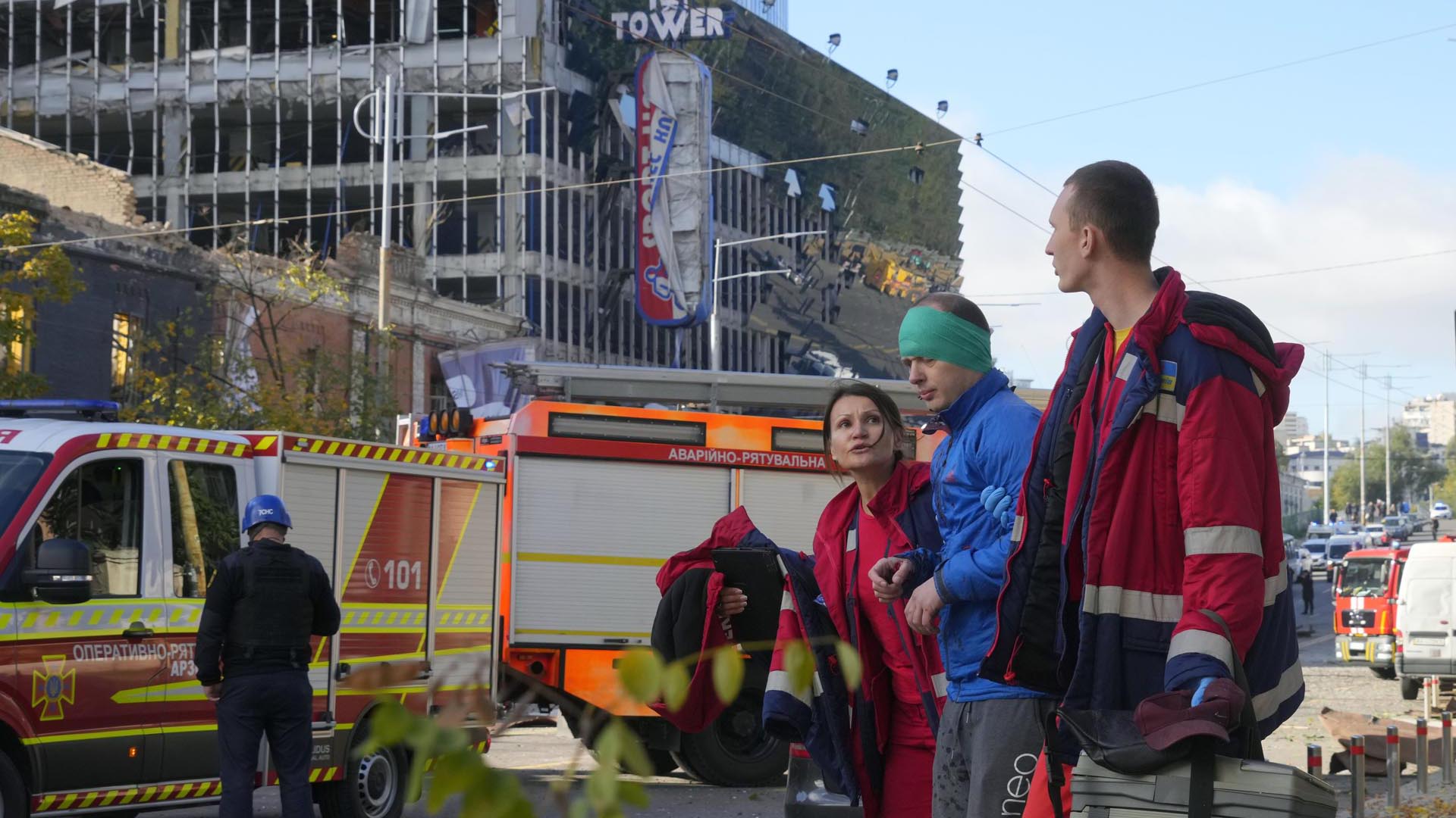 Un hombre herido recibe tratamiento médico junto a un camión de bomberos en el lugar del bombardeo ruso, en Kiev.