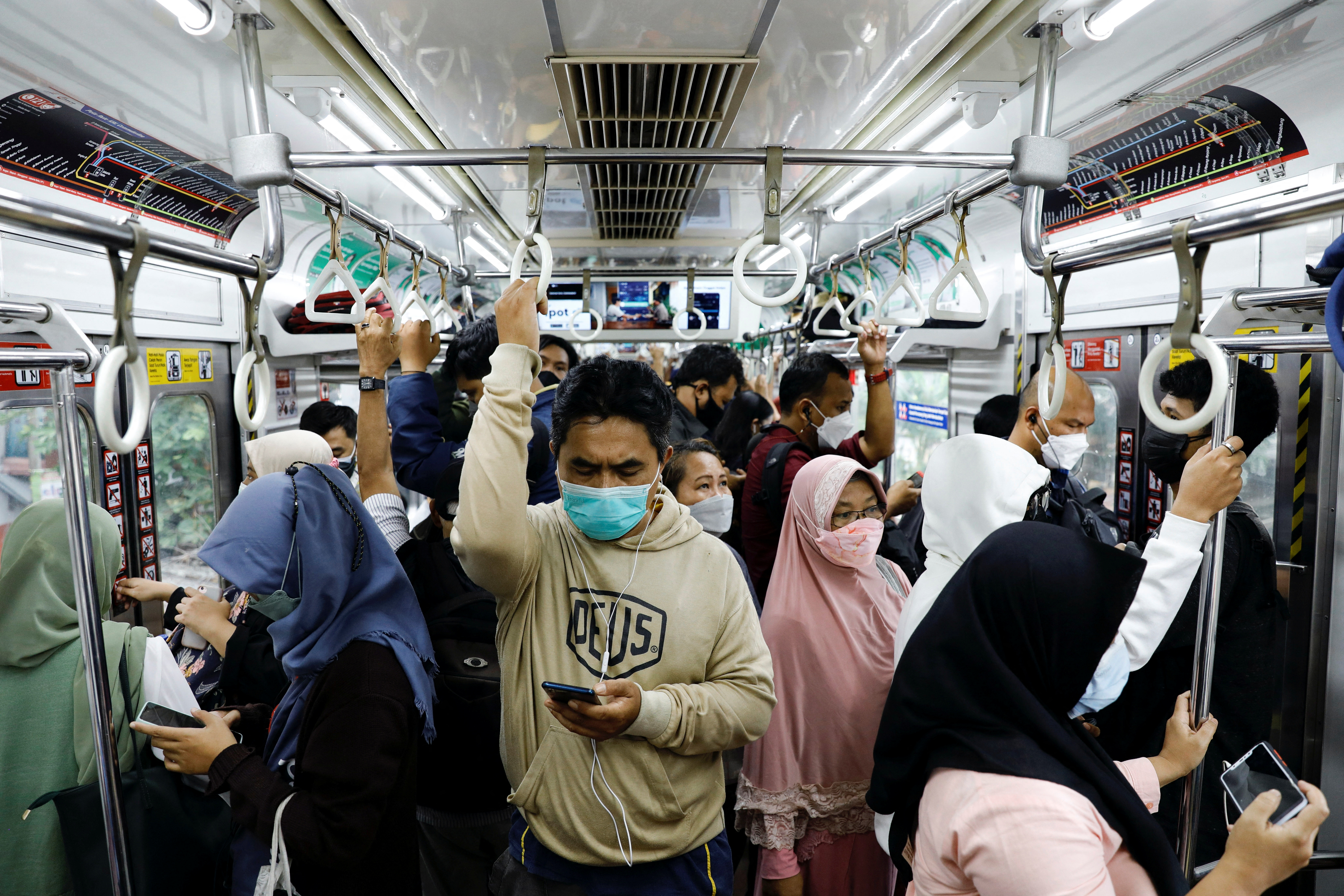 Passengers wearing protective masks stand inside a commuter train during the afternoon rush hours as the Omicron variant continues to spread, amid the coronavirus disease (COVID-19) pandemic, in Jakarta, Indonesia, January 3, 2022. REUTERS/Willy Kurniawan