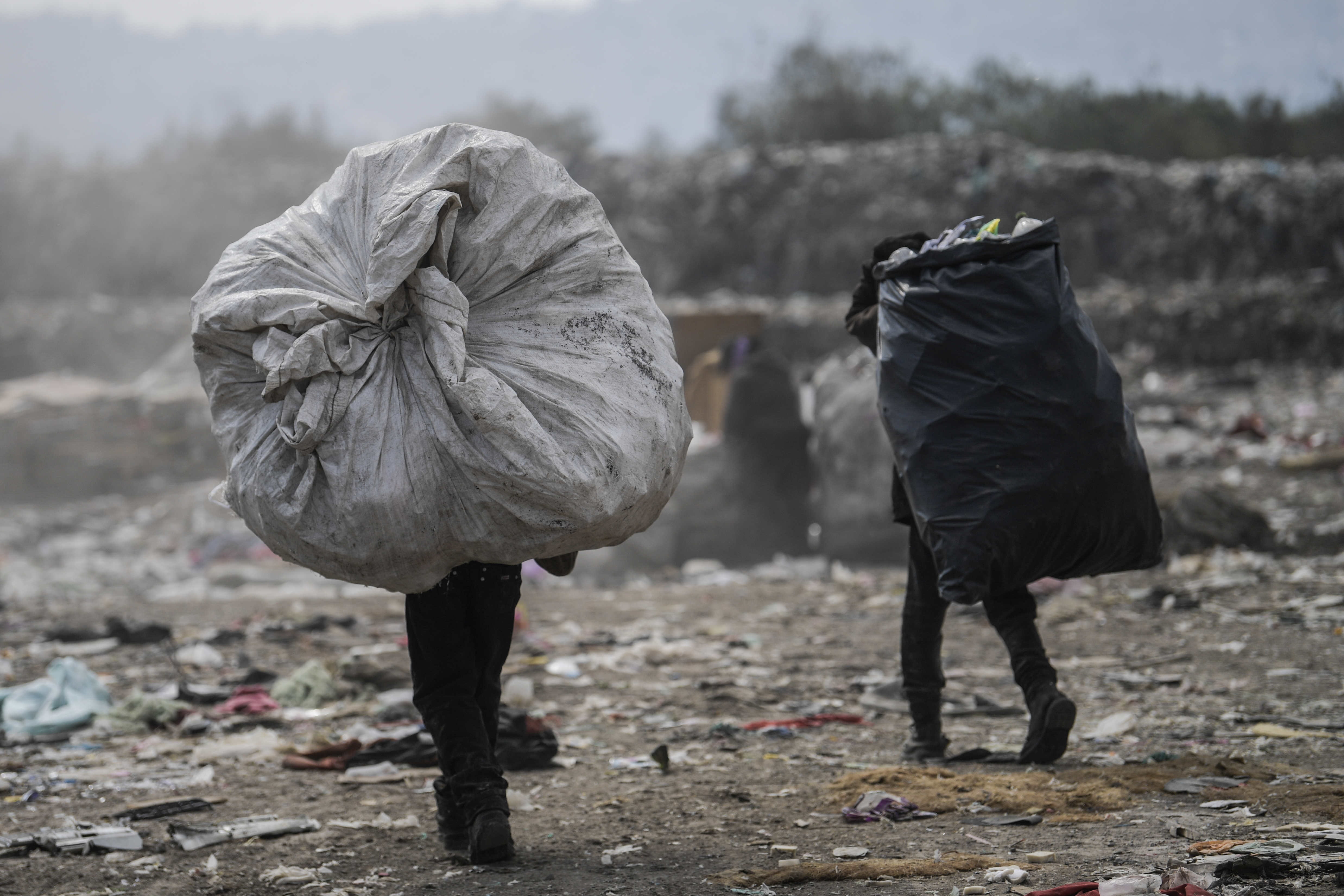 Los recolectores llevan bolsas en el basurero