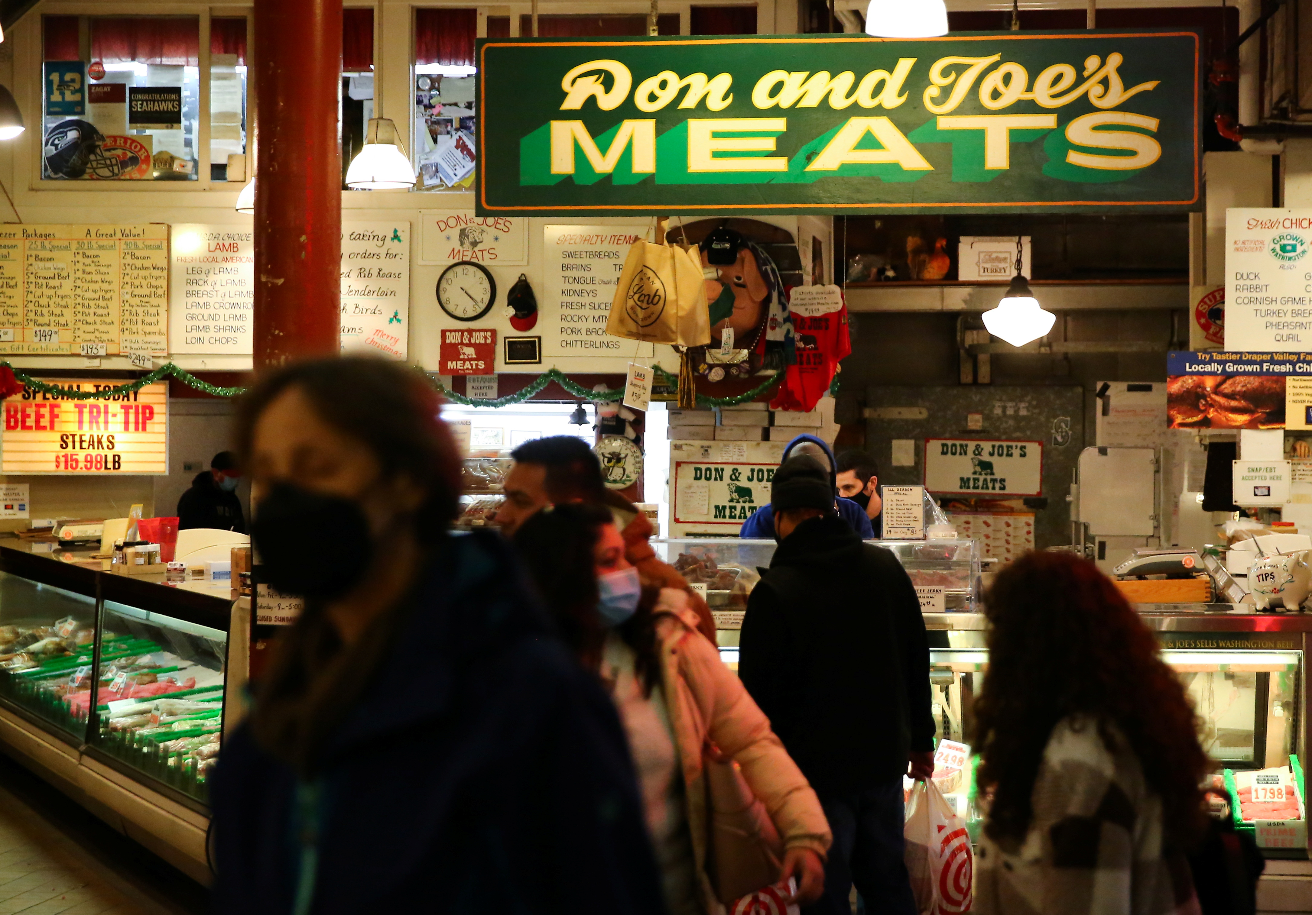Un comprador se detiene en Don and Joe's Meats en Pike Place Market mientras comienzan los preparativos para el feriado de Acción de Gracias en Seattle, Washington, EE. UU., 24 de noviembre de 2021. REUTERS / Lindsey Wasson