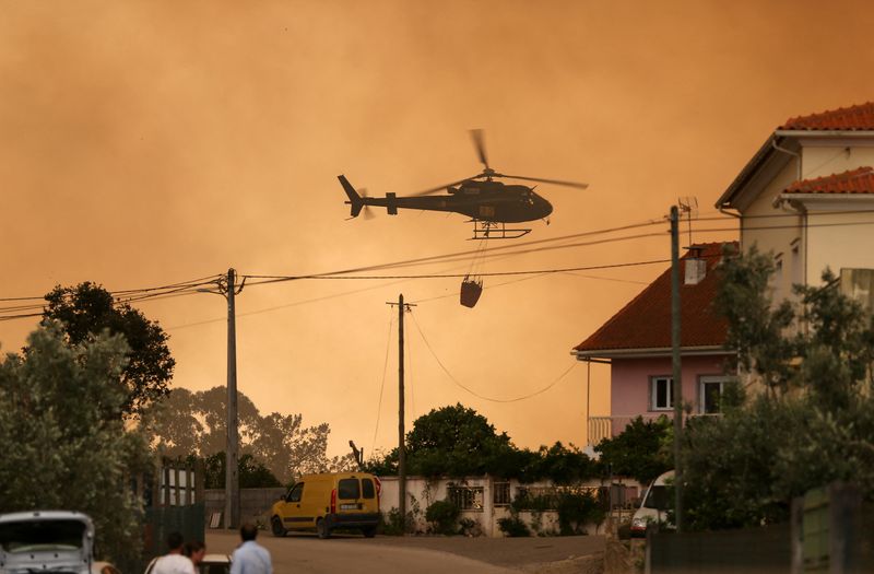 Un helicóptero de extinción de incendios trabaja para contener un incendio forestal en Leiria, Portugal (REUTERS/Rodrigo Antunes)